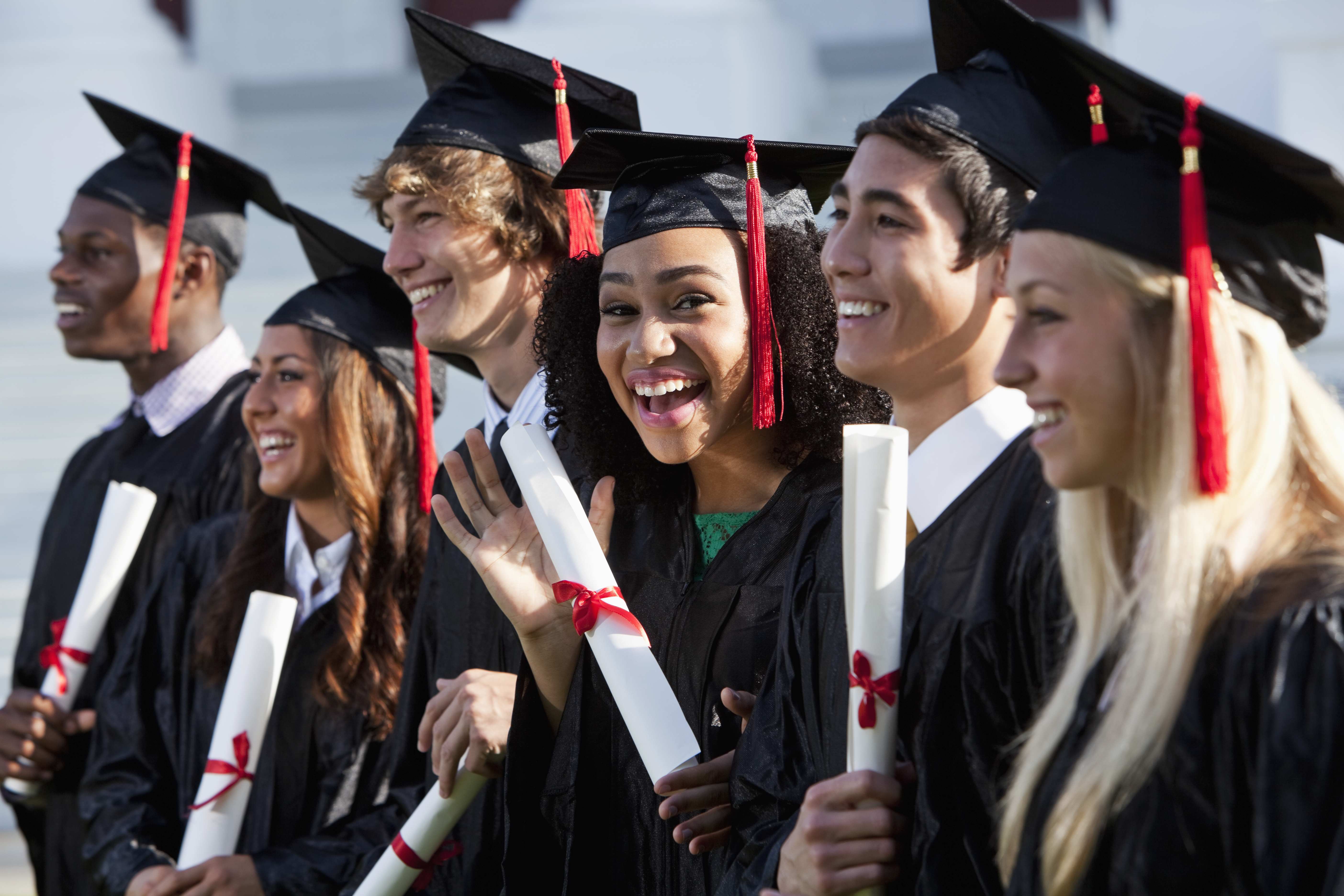 Friends graduating together, in cap and gown