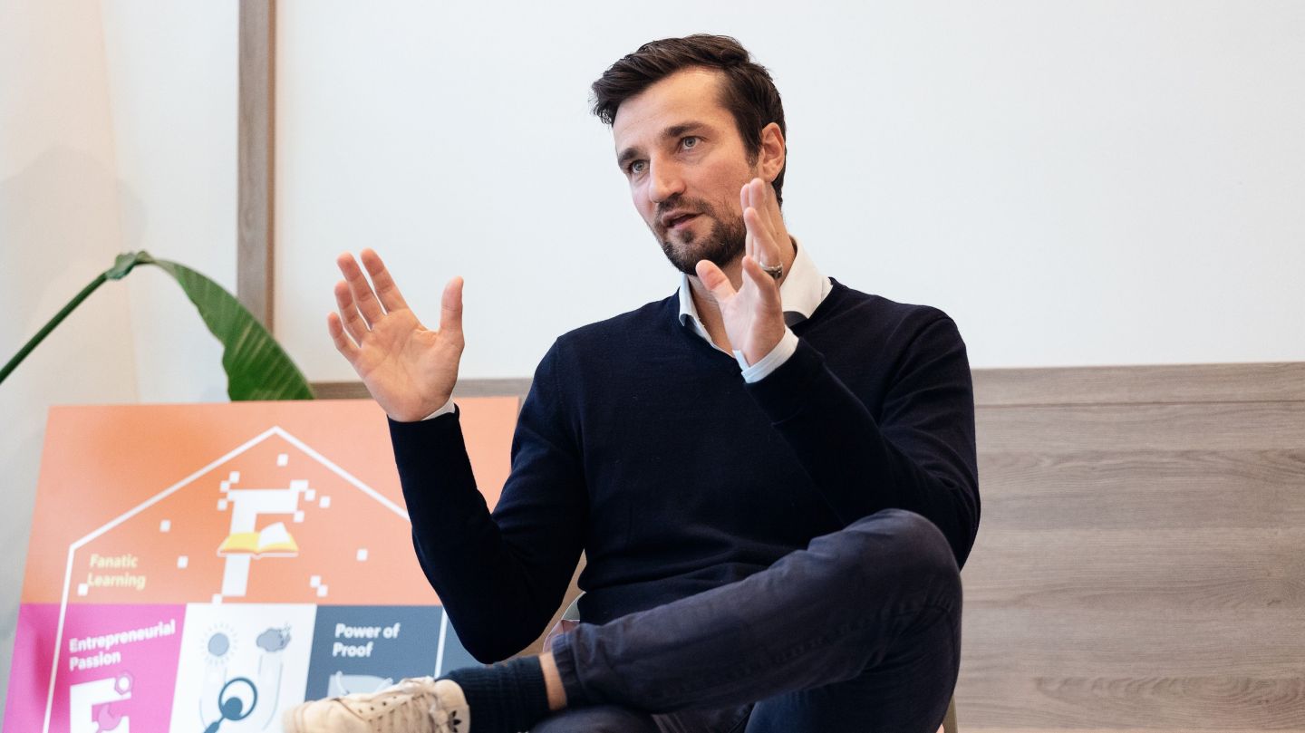 Trivago CFO Matthias Tillmann sits on stage giving a presentation