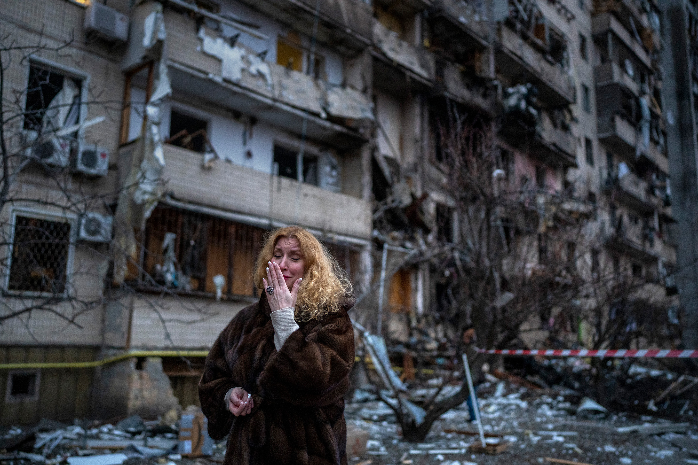 Natali Sevriukova reacts next to her house following a rocket attack the city of Kyiv.