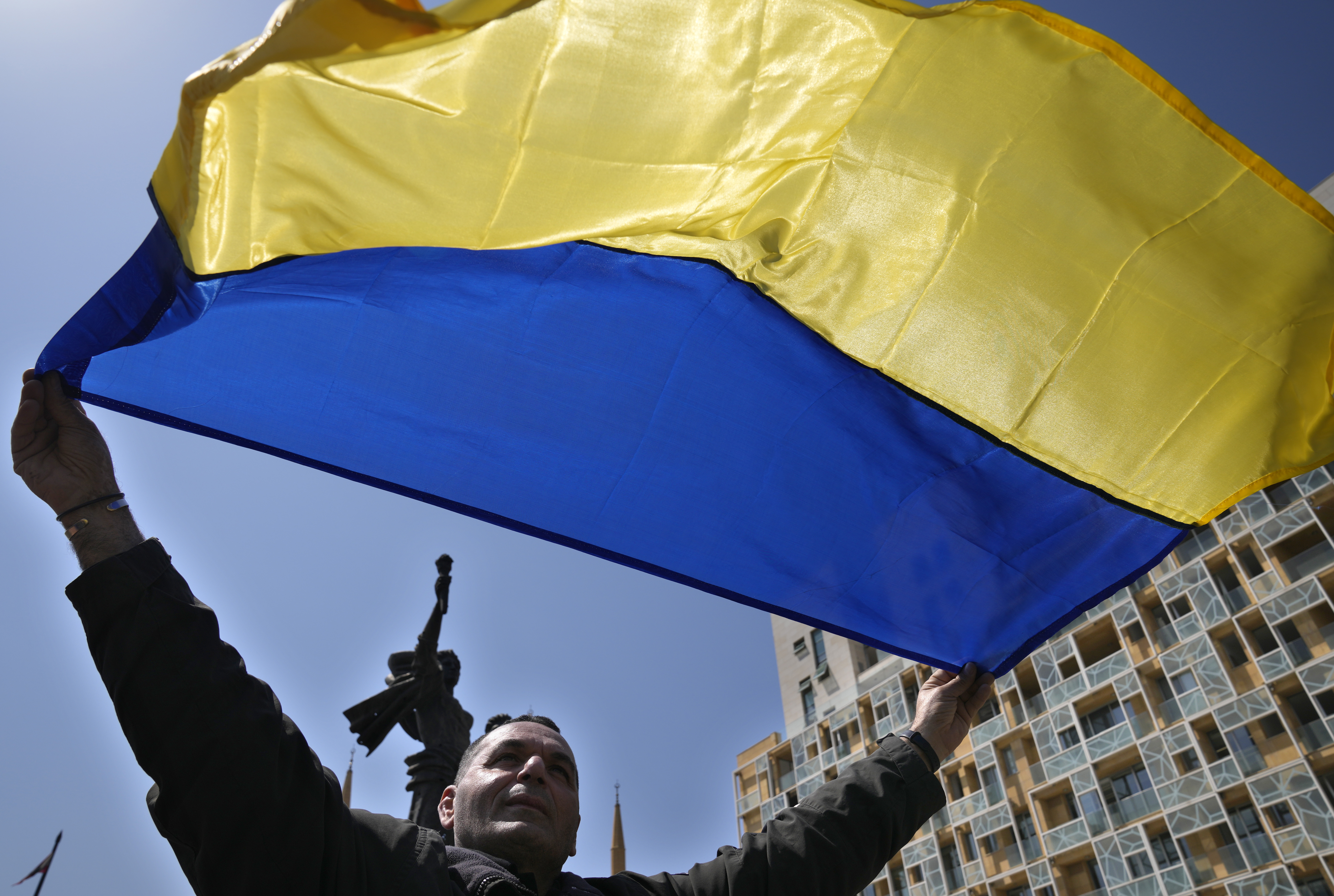 A Ukrainian man who lives in Lebanon waves the colors of his national flag, during a protest against the Russian invasion of his country, in Beirut, Lebanon, Sunday, March 27.