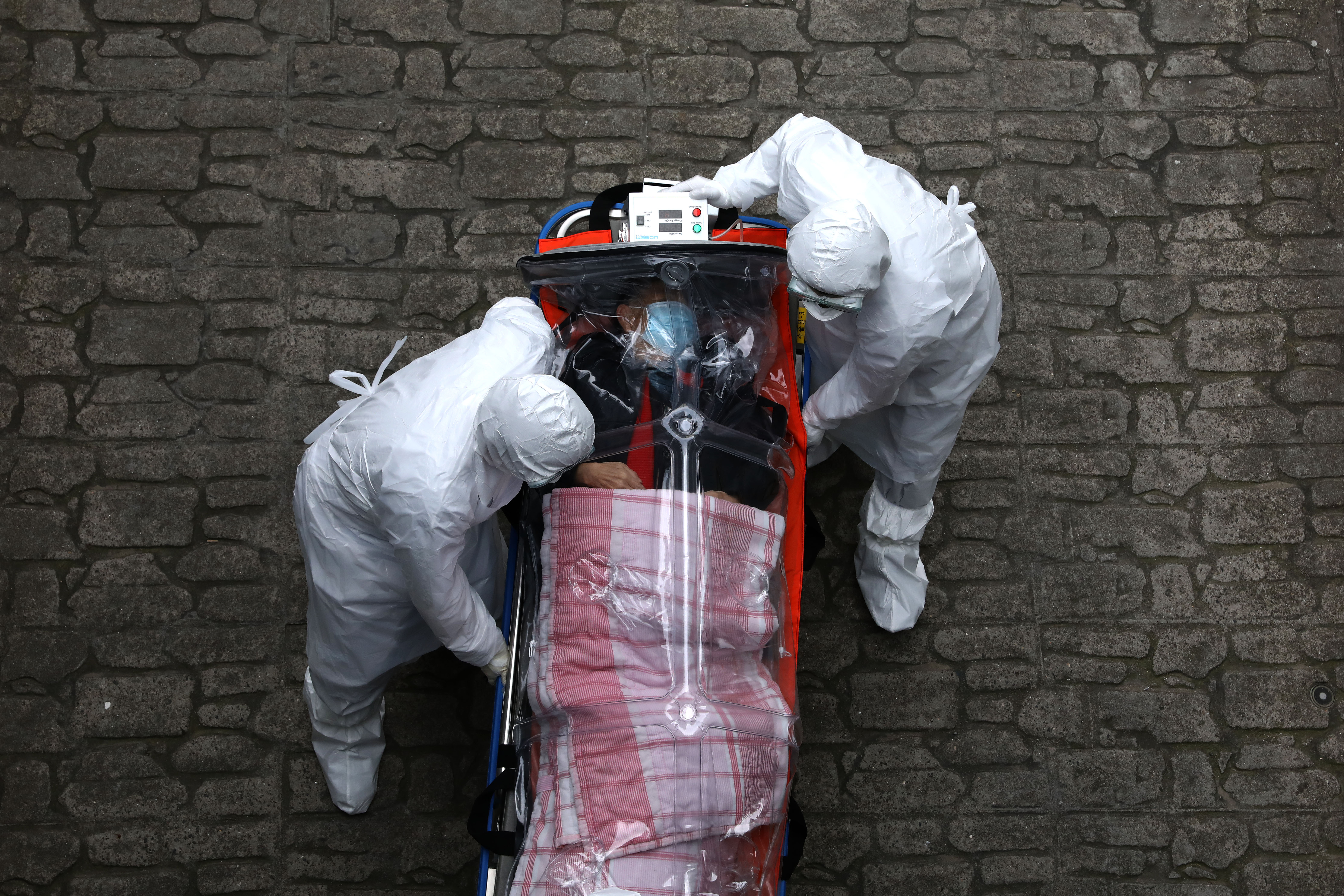 Medical staff, wearing protective gear, move a patient infected with the coronavirus (COVID-19) from an ambulance to a hospital on March 09, 2020, in Seoul, South Korea.