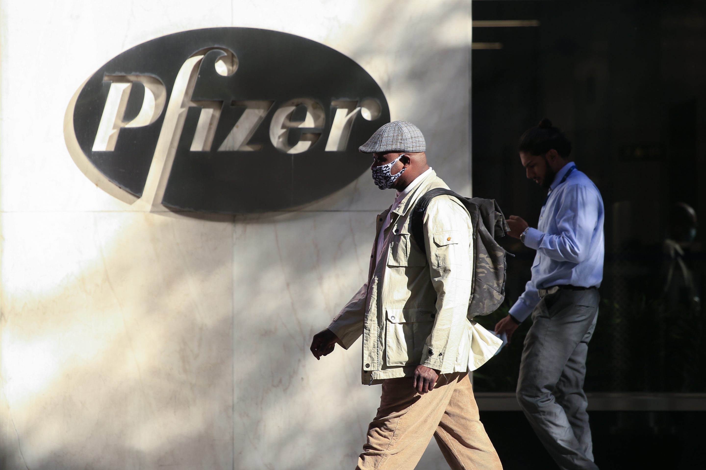 People walk by Pfizer building in NYC