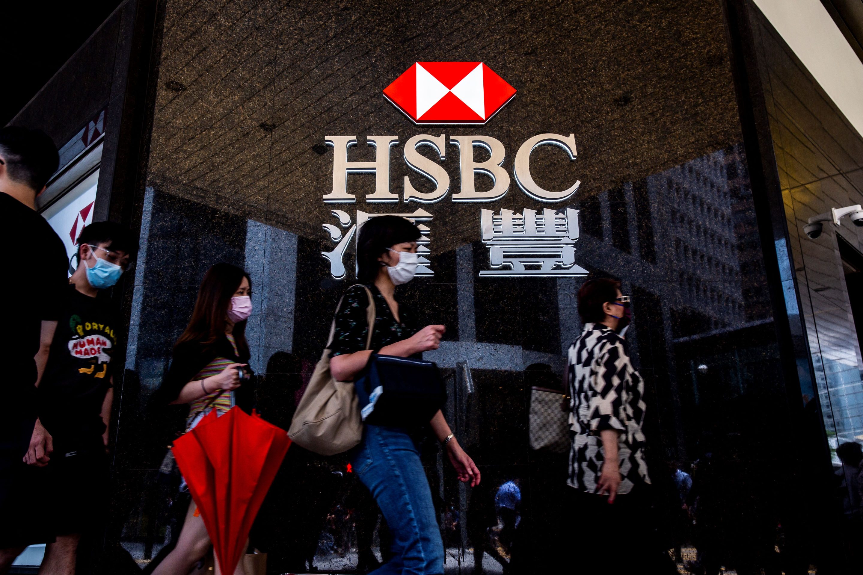 Pedestrians walk past an HSBC branch bank in Hong Kong