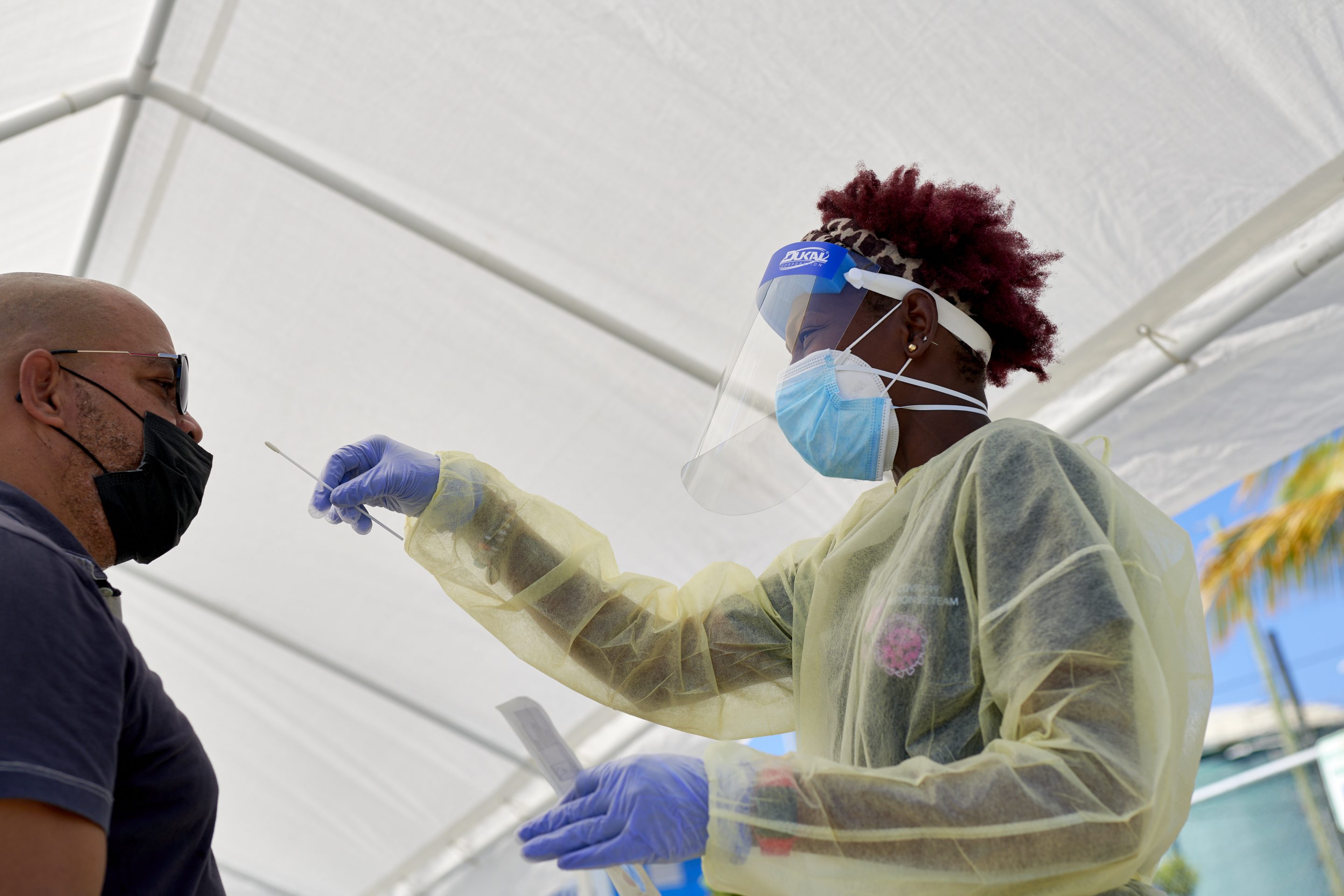 A healthcare worker conducts a swab test at a drive through Covid-19 testing site in Cruz Bay, Saint John, U.S. Virgin Islands, U.S., on Wednesday, Feb. 2, 2022.
