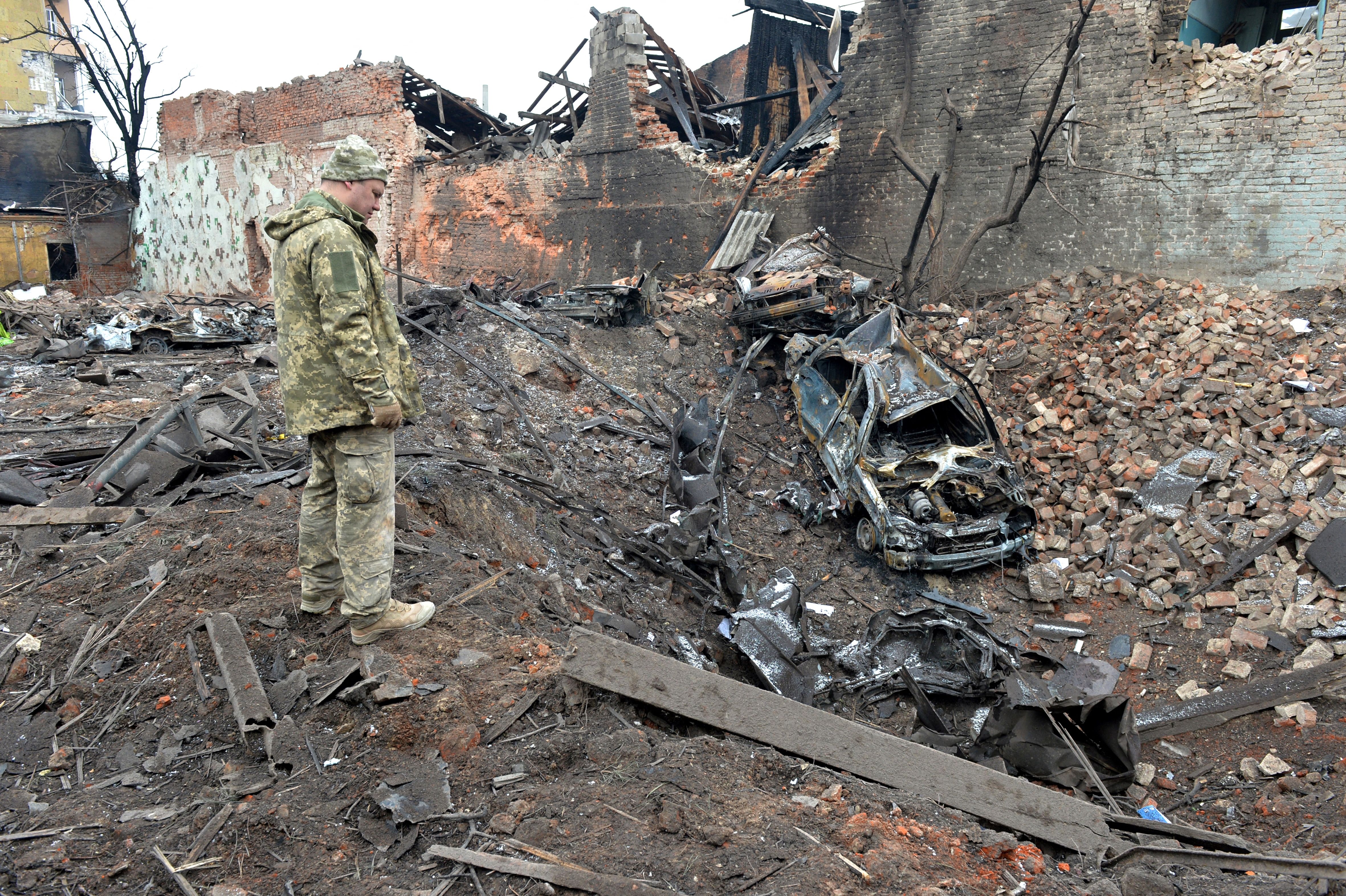 A Ukrainian serviceman looks at destructions following a shelling in Ukraine's second-biggest city of Kharkiv on March 7, 2022.