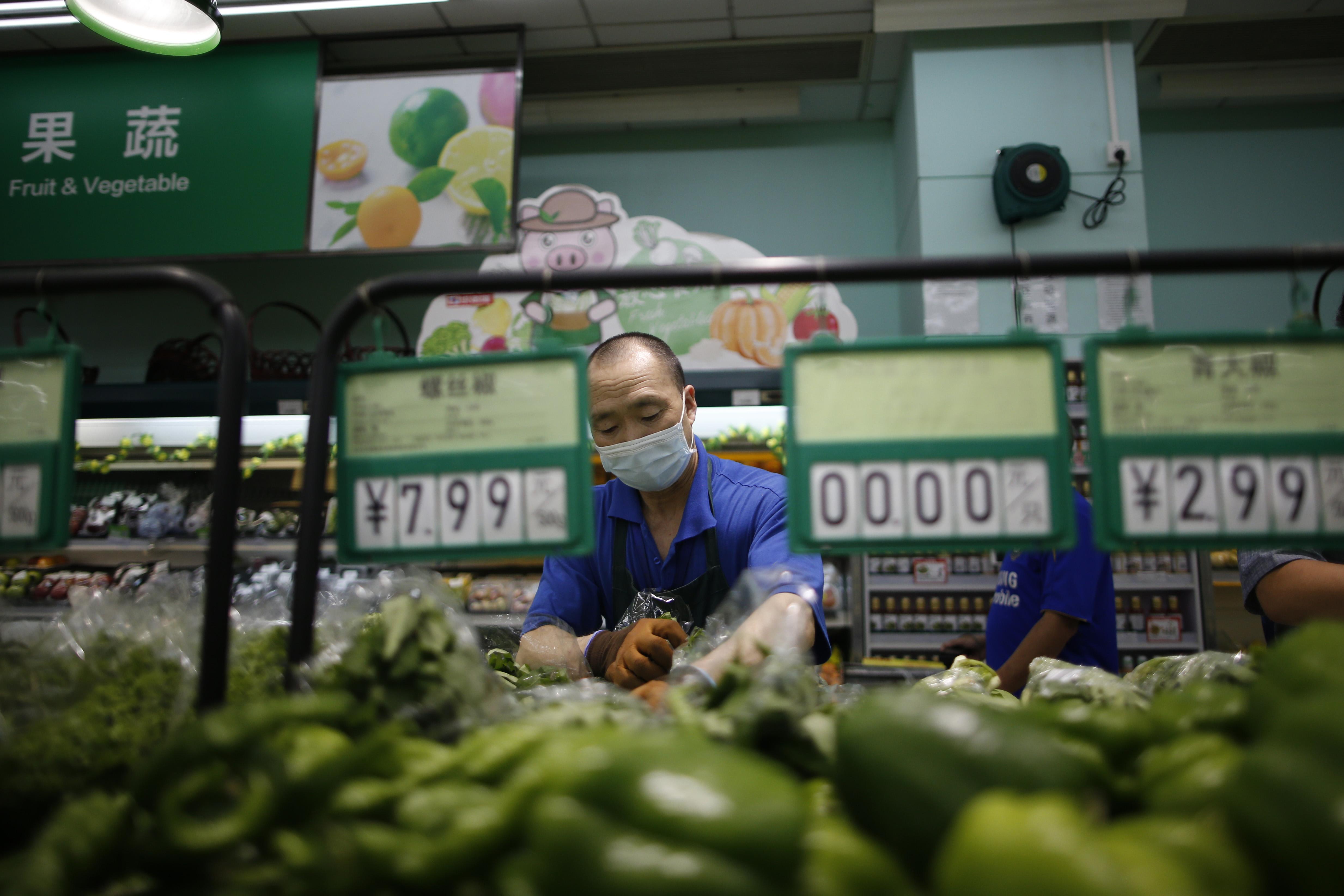 People shop for vegetables at a supermarket on June 19, 2020, in Beijing, China.