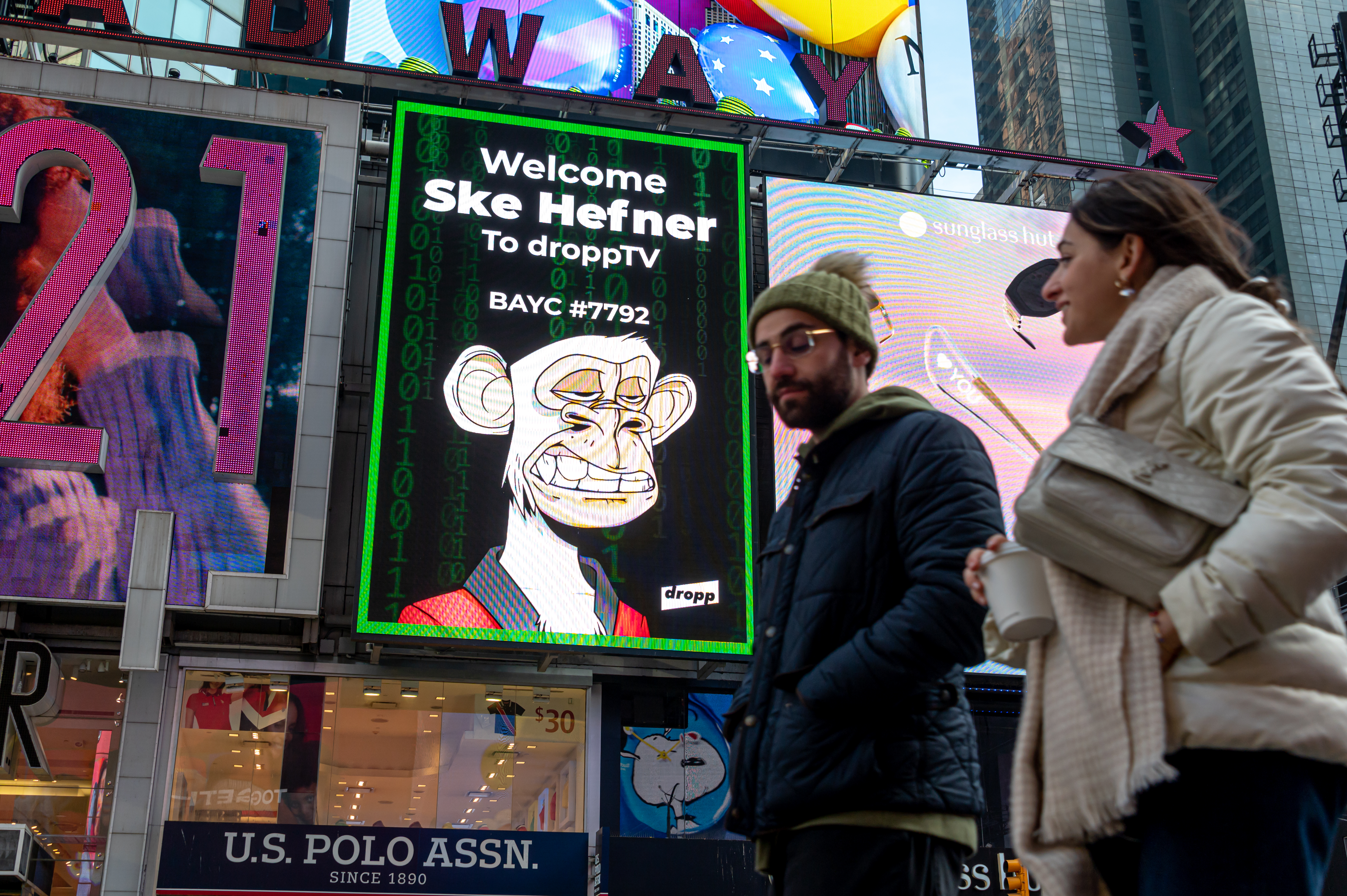 People walk by a Bored Ape Yacht Club NFT billboard in Times Square on January 25 in New York City.