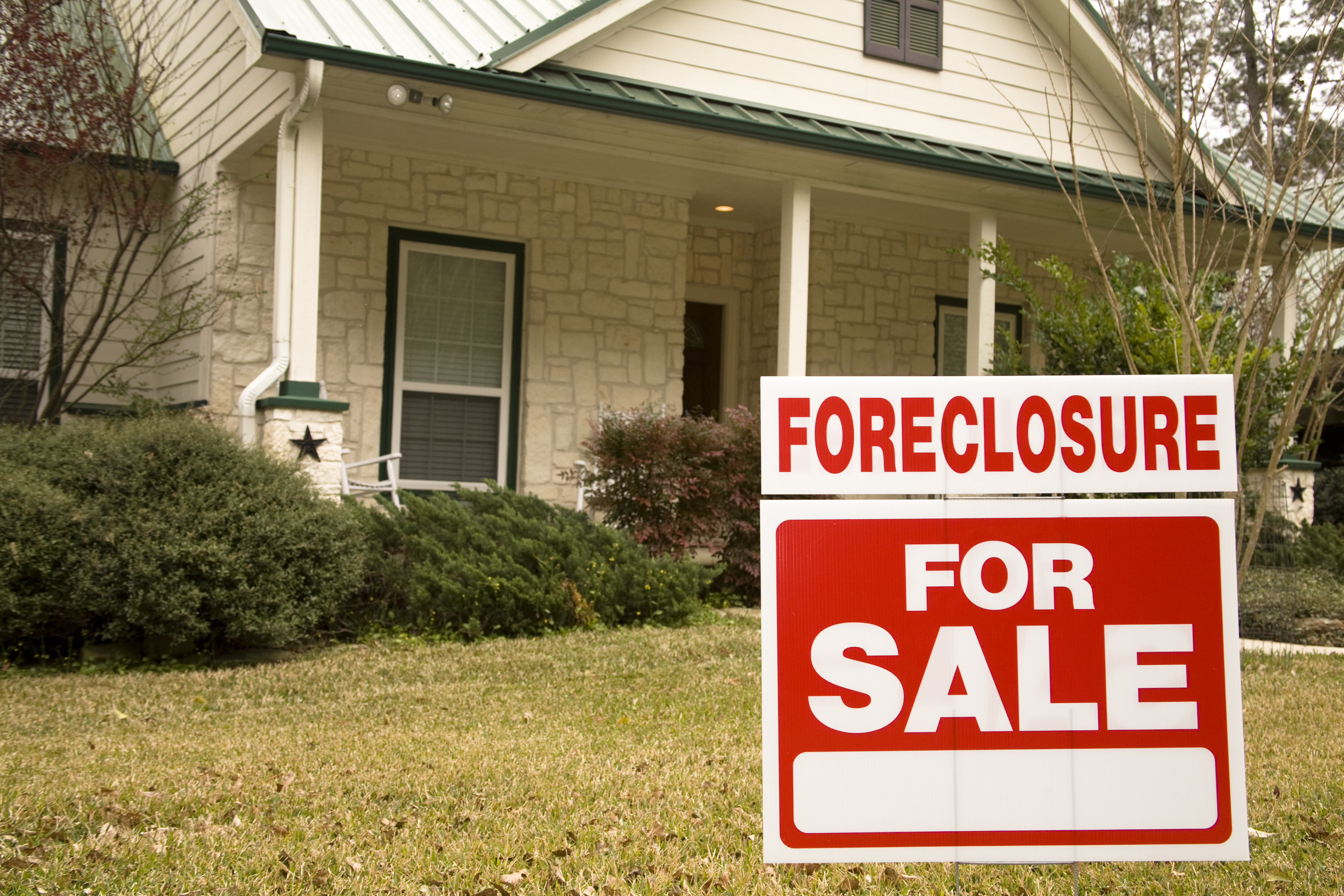 A foreclosure sign in front of a house.