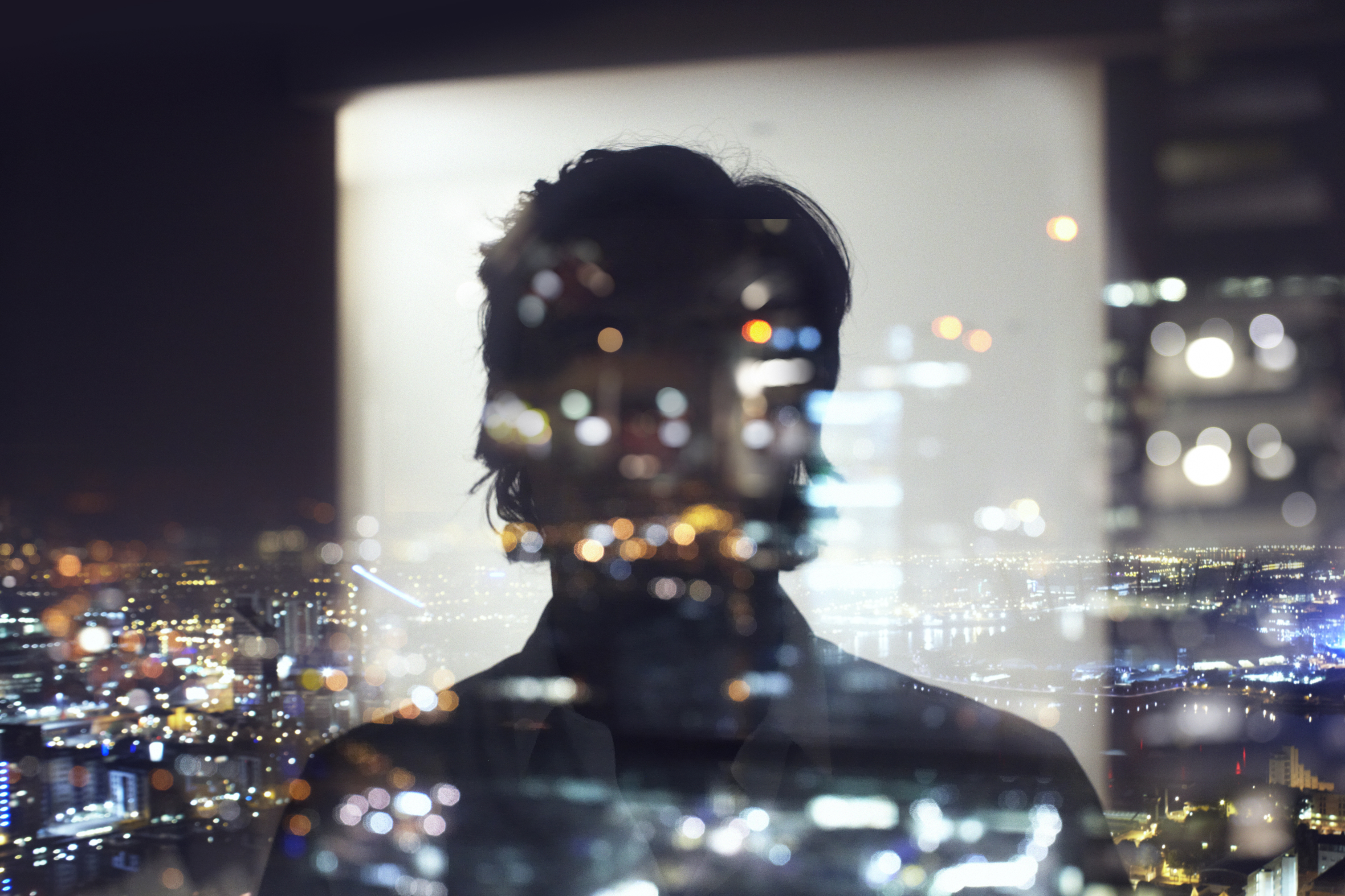 reflection of business man at night with city lights