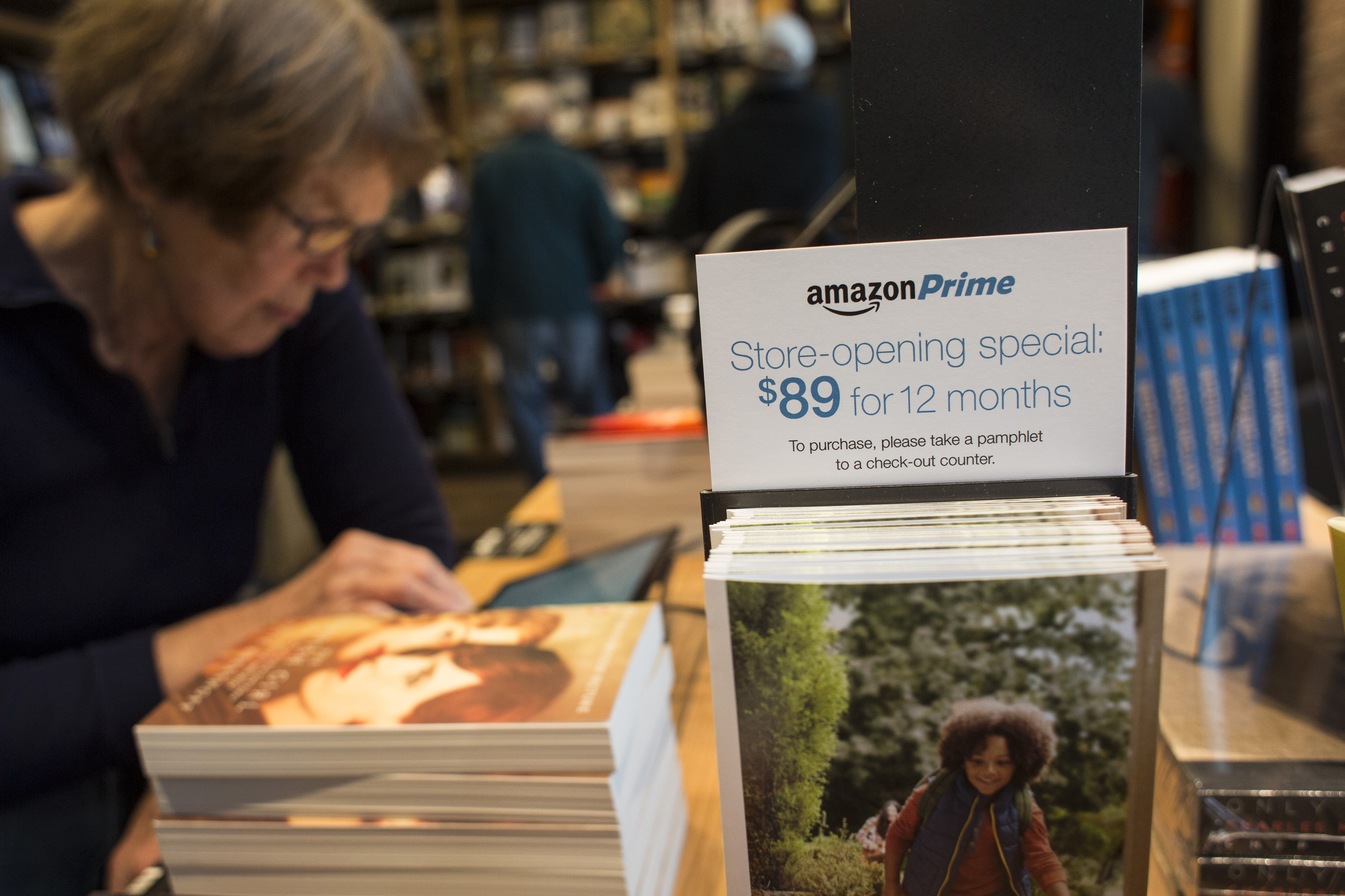 A sign advertises the Amazon Prime service as a customer shops at the Amazon Books store, the company's first brick-and-mortar bookstore, in Seattle, Wash., on Nov. 3, 2015.