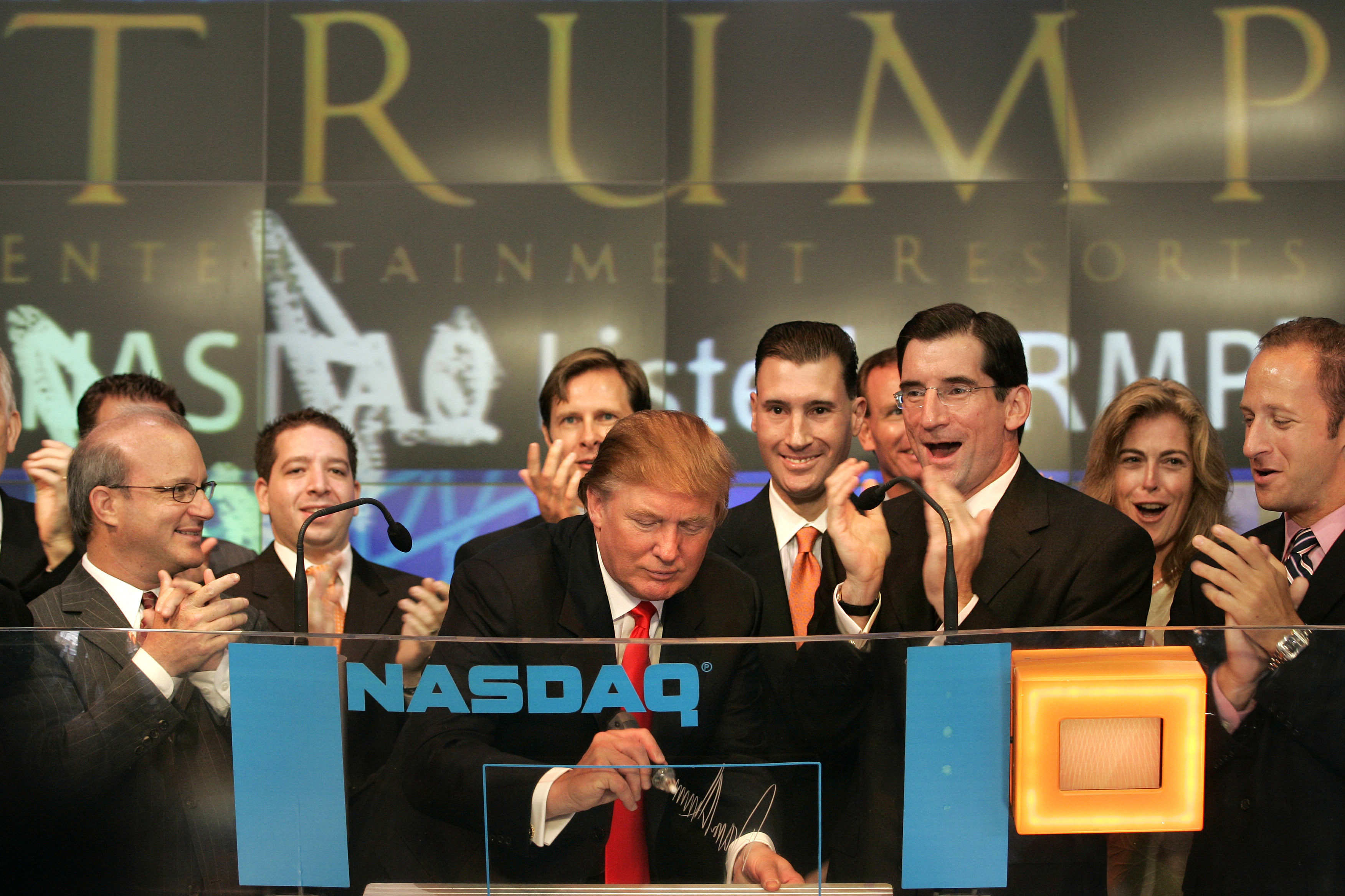 Donald Trump signs his autograph as he opens the Nasdaq Market September 20, 2005, in New York City.