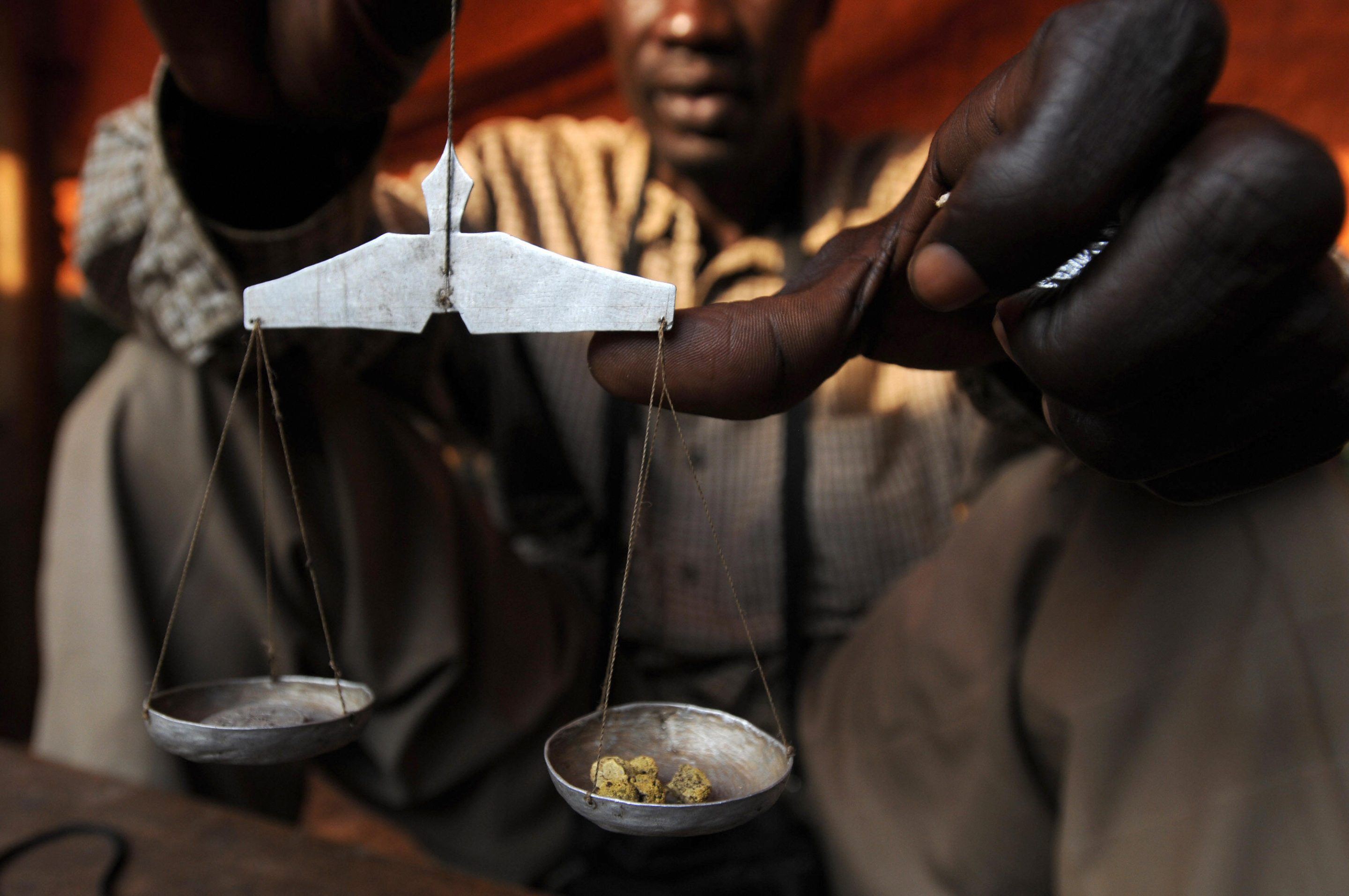 A man weighs gold in a market.