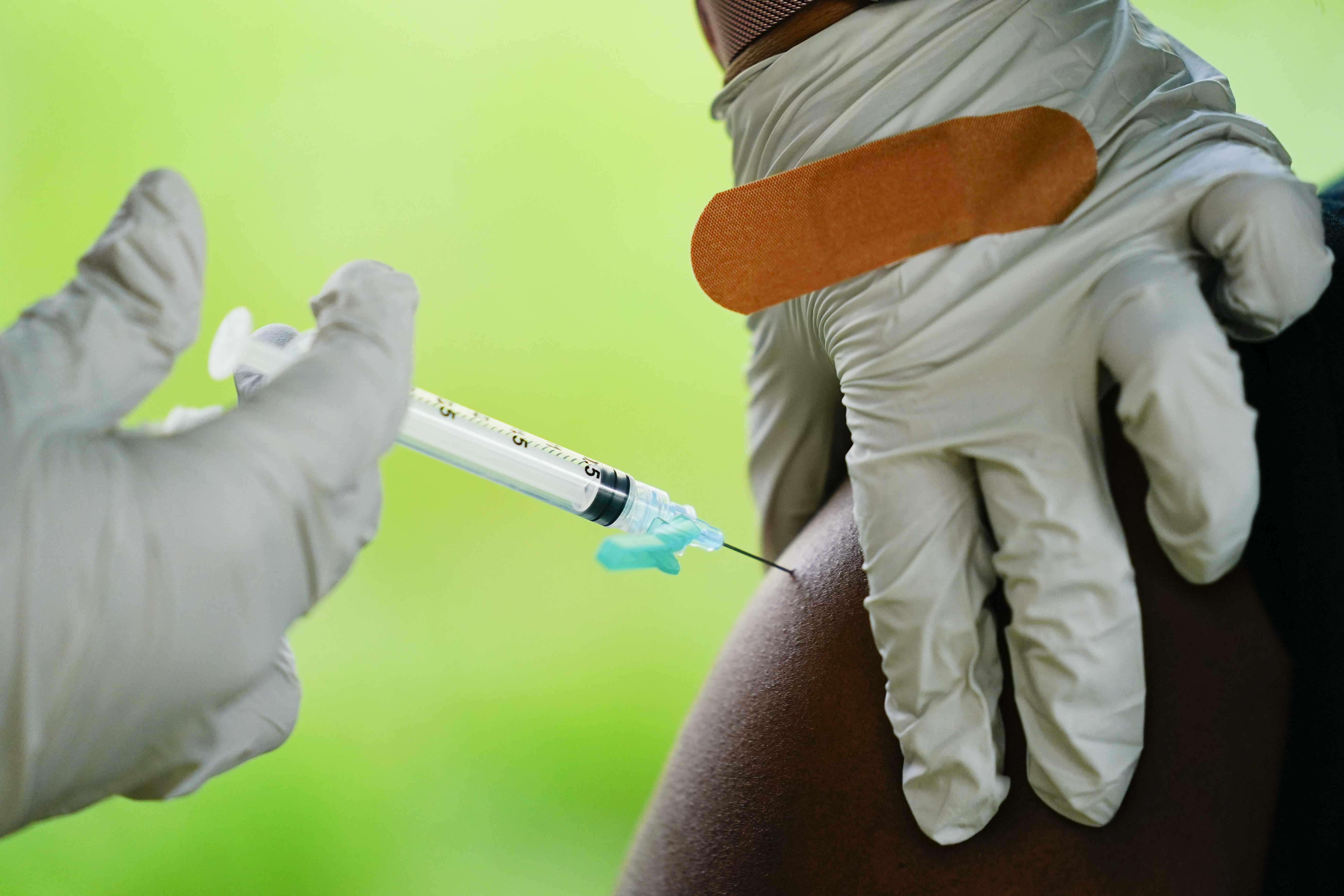 A health worker administers a dose of COVID-19 vaccine during a vaccination clinic in Reading, Pa. COVID-19 vaccinations are at a critical juncture as companies test whether new approaches like combination shots or nasal drops can keep up with a mutating coronavirus — even though it’s not clear if any change is needed.