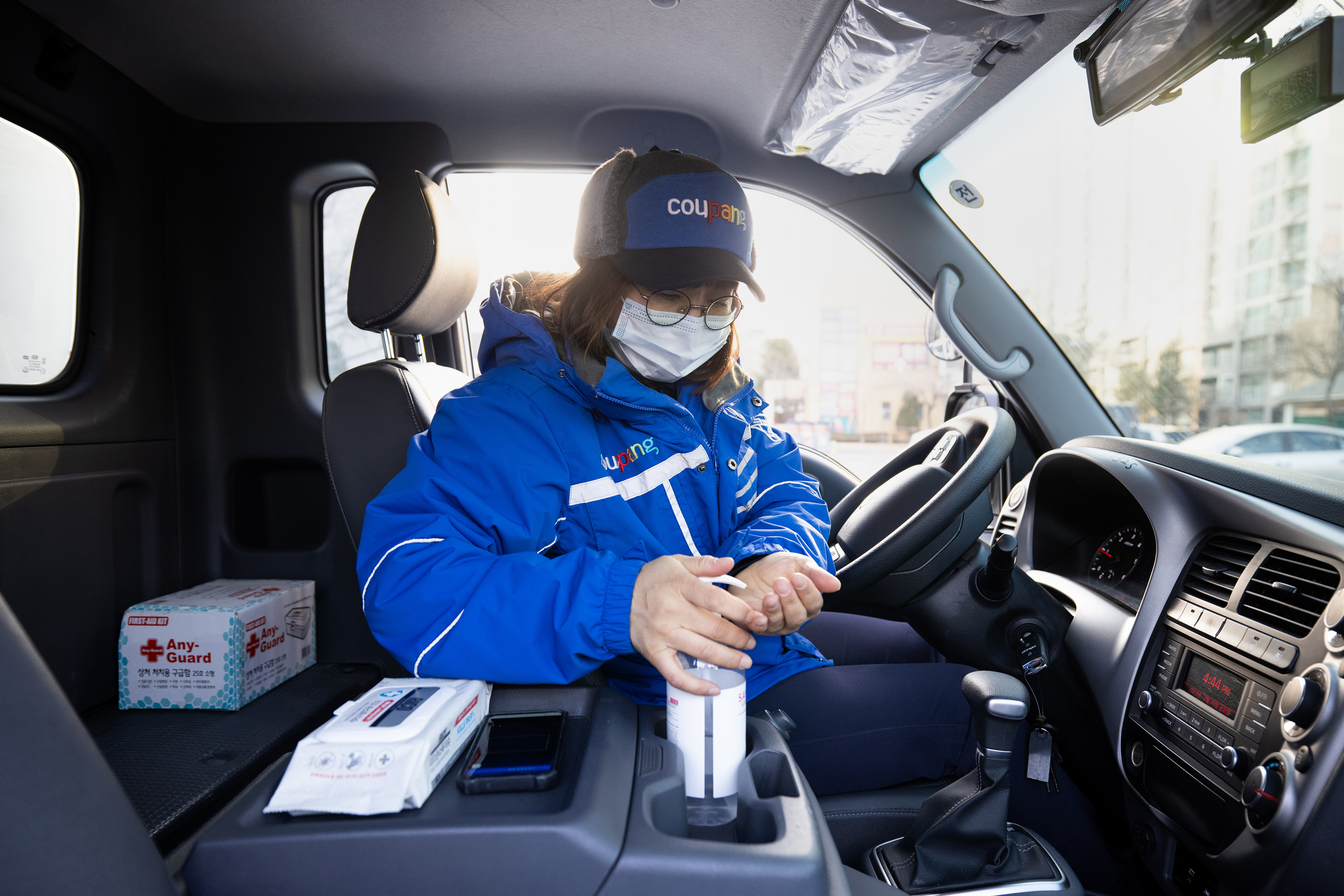 A Coupang Corp. employee wearing a protective mask uses hand sanitizer inside a delivery truck in Bucheon, South Korea.