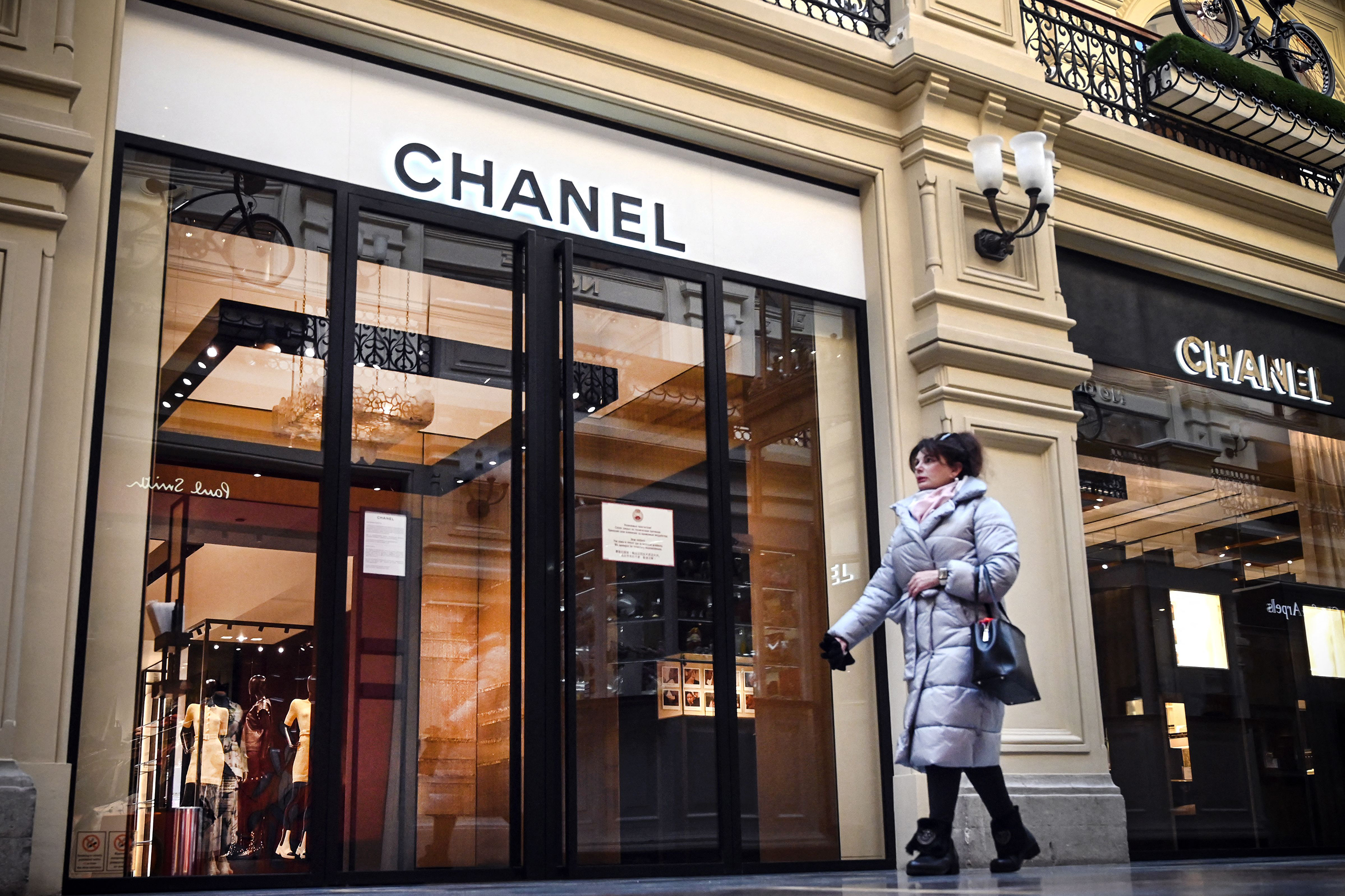 A woman walks past a closed Chanel shop in Moscow on March 10, 2022.