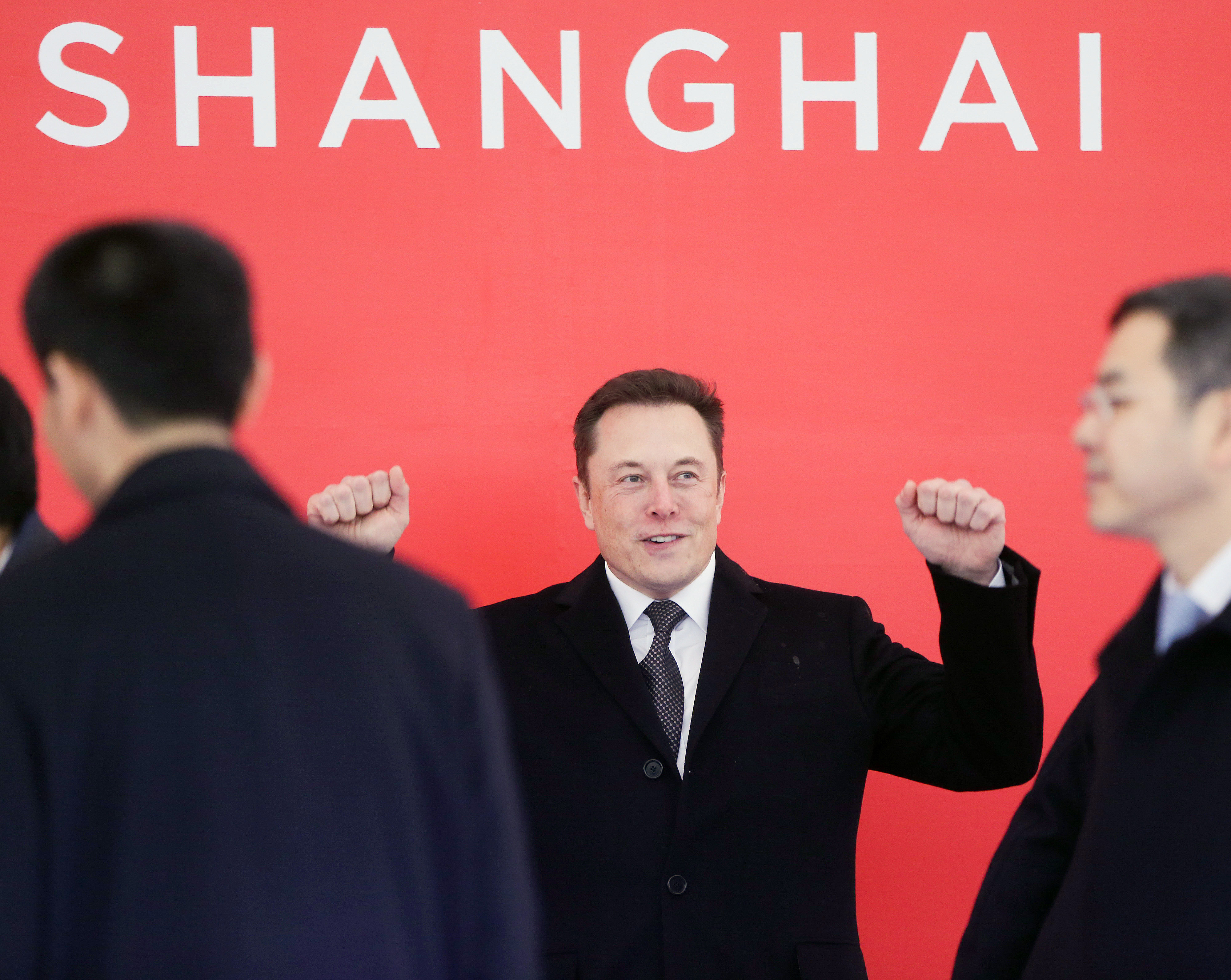 Elon Musk seen dancing beneath a sign reading 'Shanghai'
