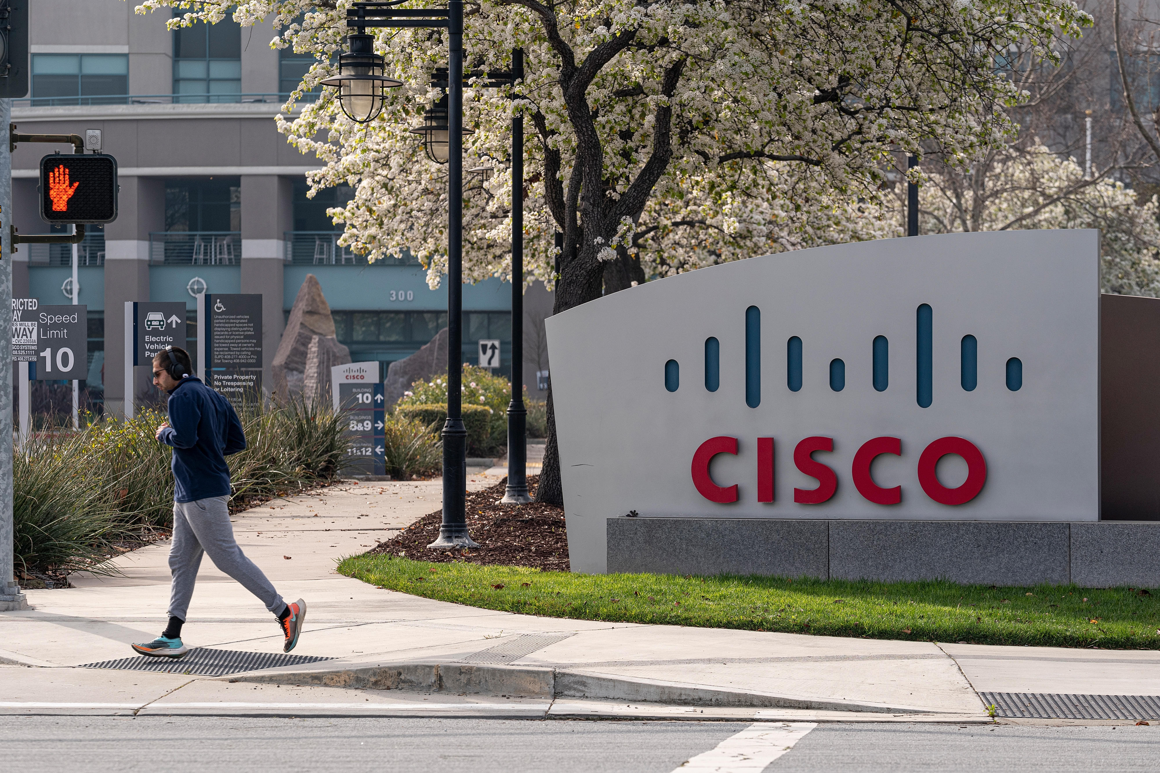 A runner jogs past Cisco Systems headquarters in San Jose. Cisco tops this year’s “Best Companies to Work For” list.