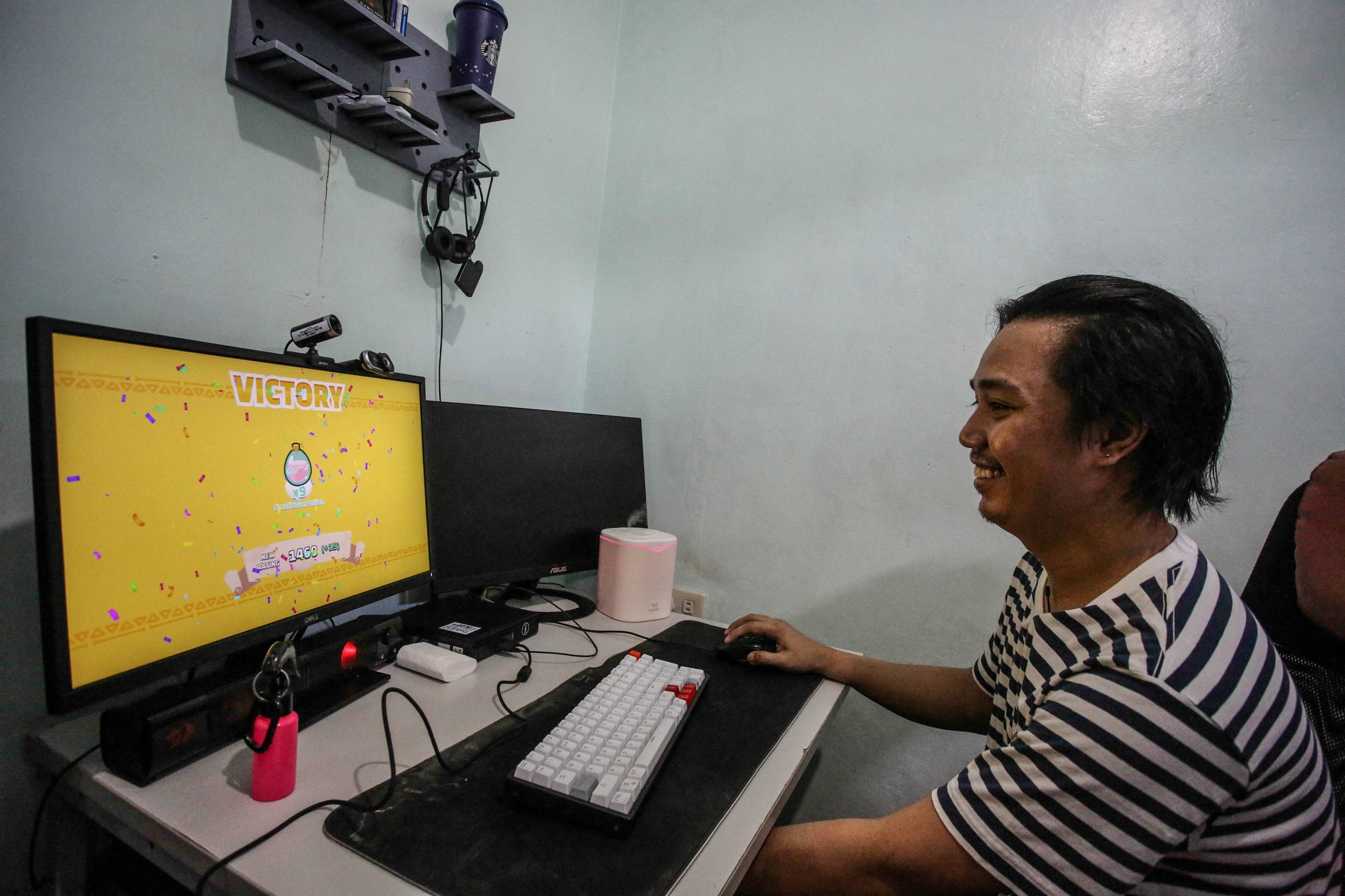 Dominic Lumabi plays Axie Infinity on his computer in Marikina, near Manila, in December 2021.