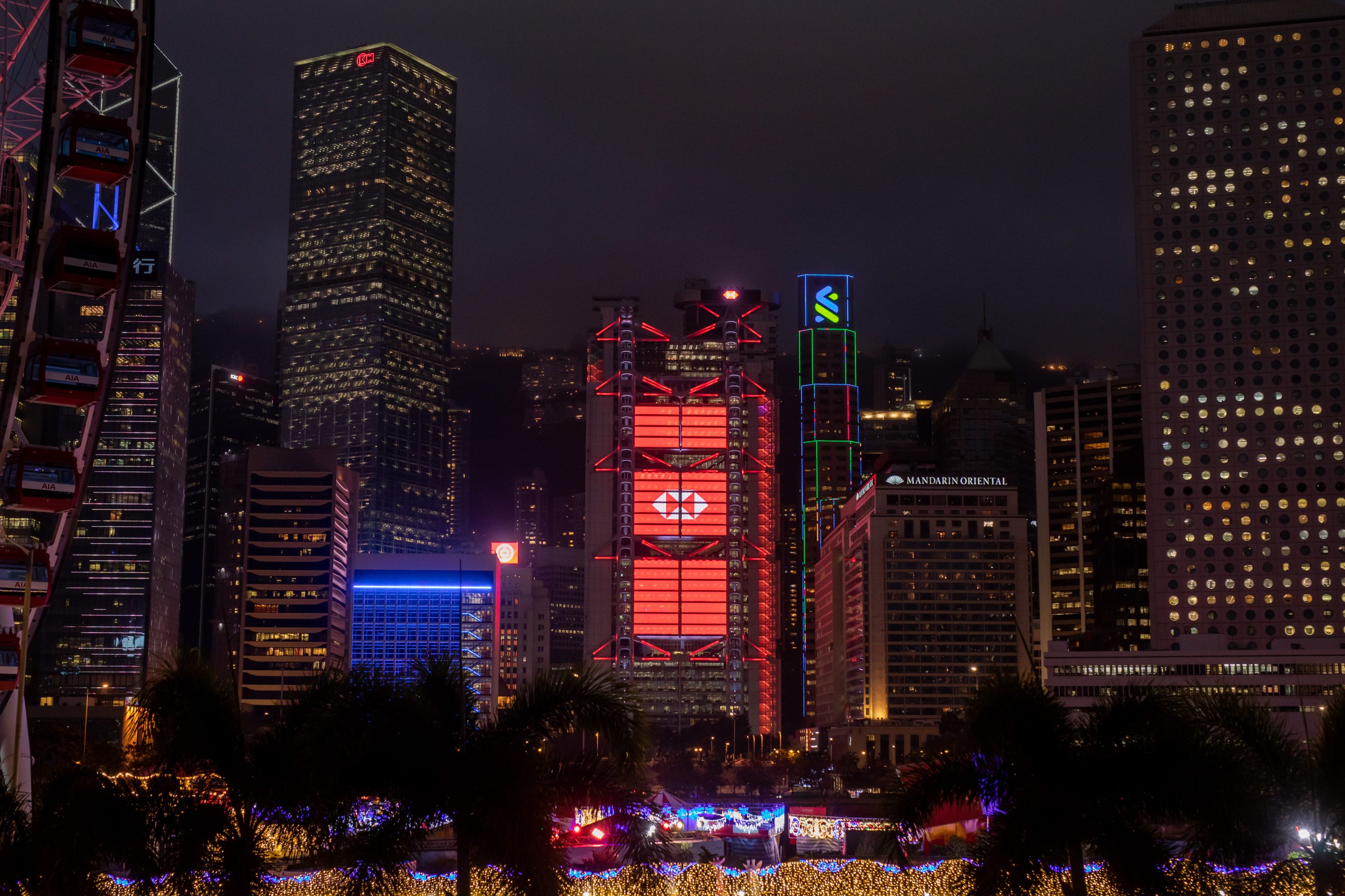 The illuminated HSBC Holdings headquarters, center, at night in Hong Kong.
