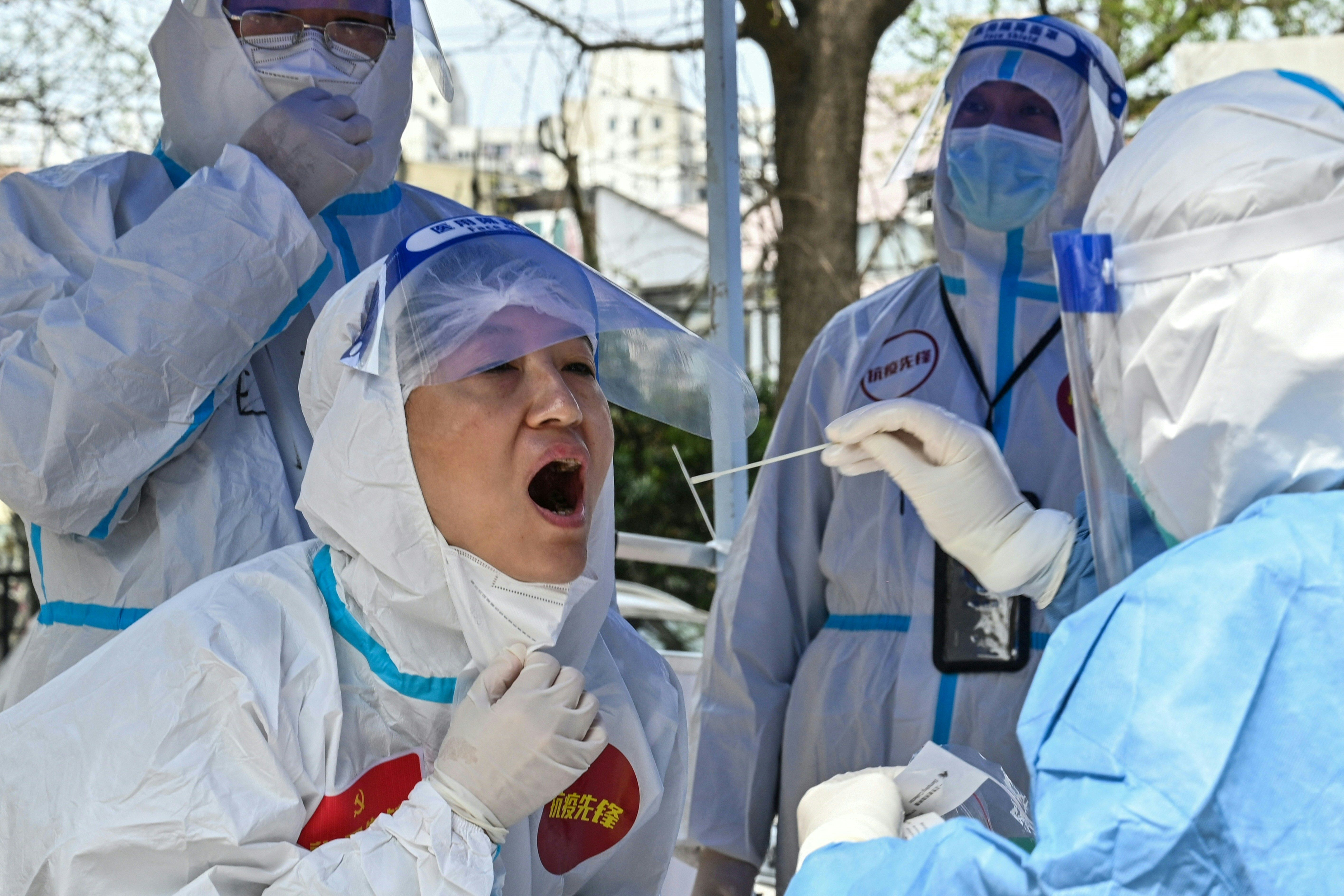 Workers and volunteers are tested as they conduct their duties in a compound where the residents are tested for the Covid-19 coronavirus during the second stage of a pandemic lockdown in Jing' an district in Shanghai on April 1.