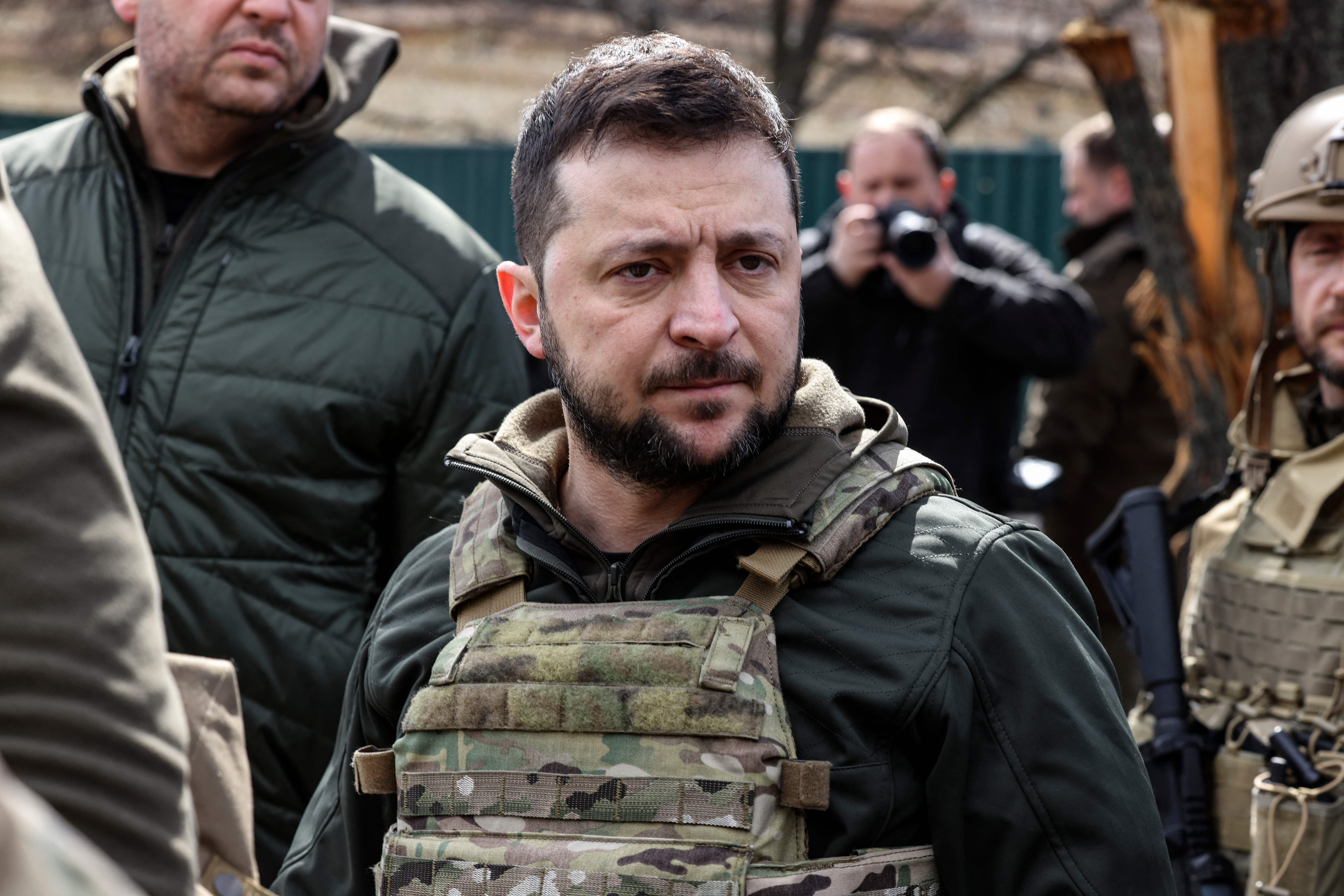 Ukainian President Volodymyr Zelensky stands in the town of Bucha, northwest of the Ukrainian capital Kyiv, on April 4, 2022. - Ukraine's President Volodymyr Zelensky said on April 3, 2022 the Russian leadership was responsible for civilian killings in Bucha, outside Kyiv, where bodies were found lying in the street after the town was retaken by the Ukrainian army.