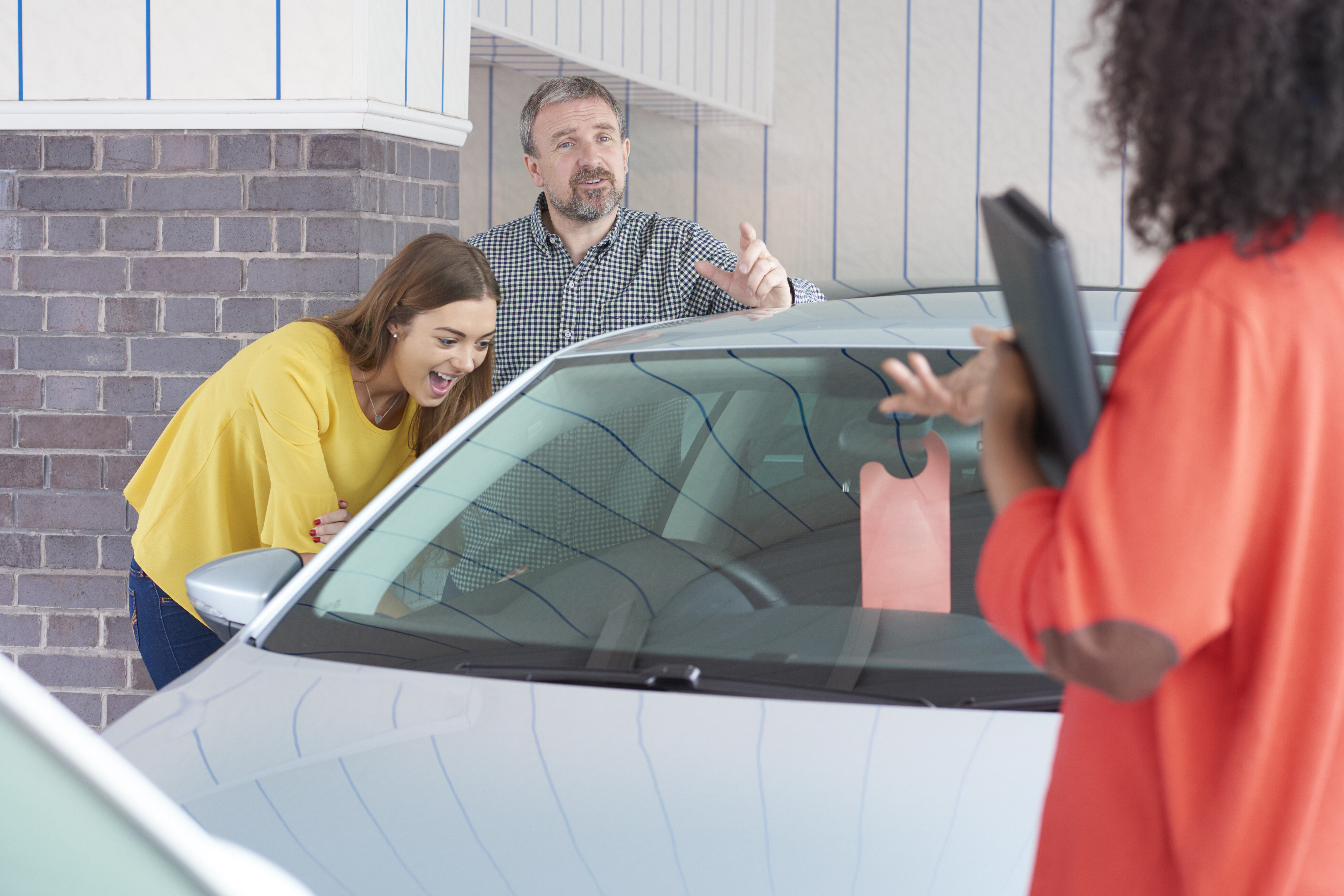 People looking at used cars.