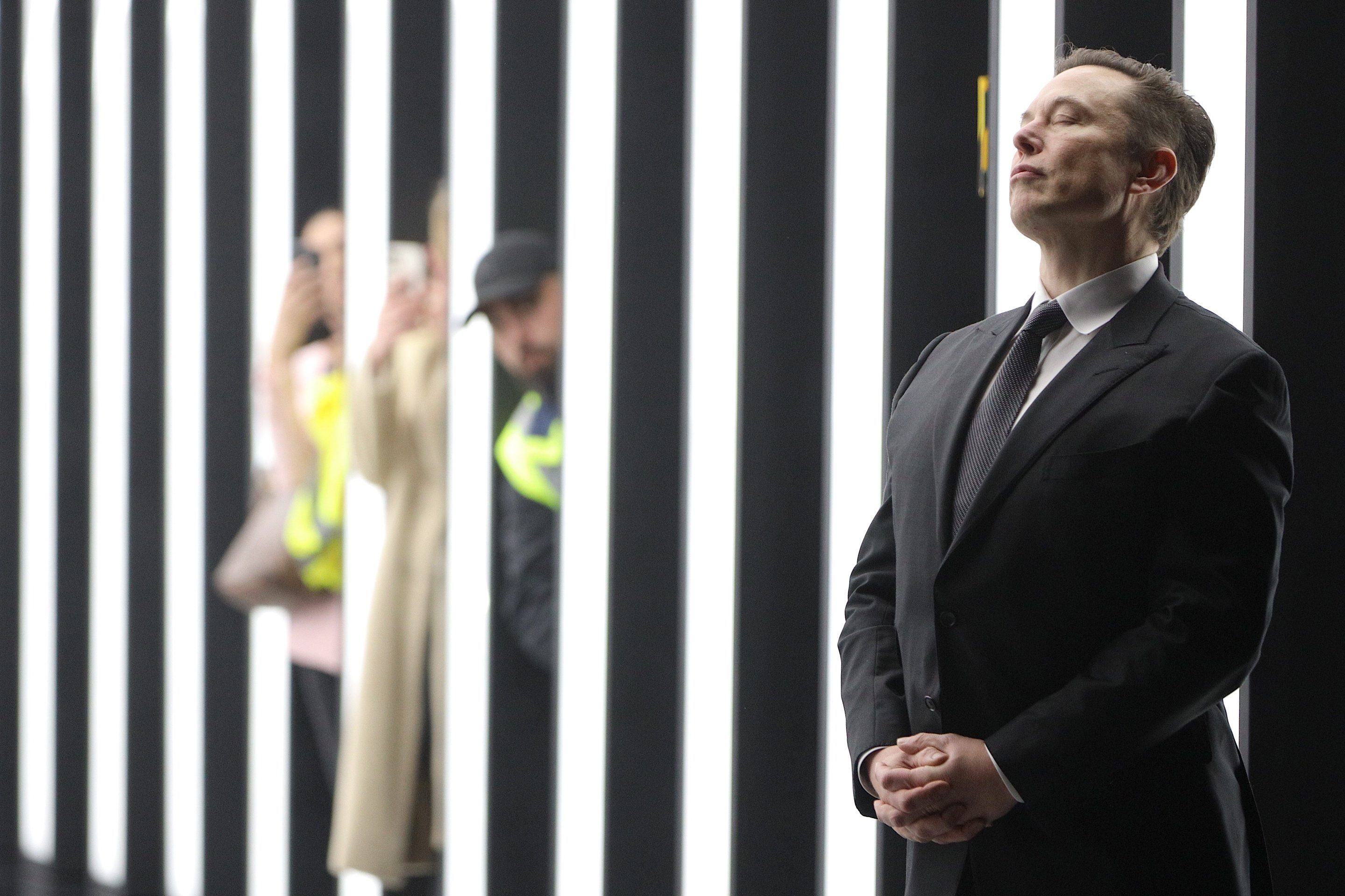 Elon Musk with hands folded.