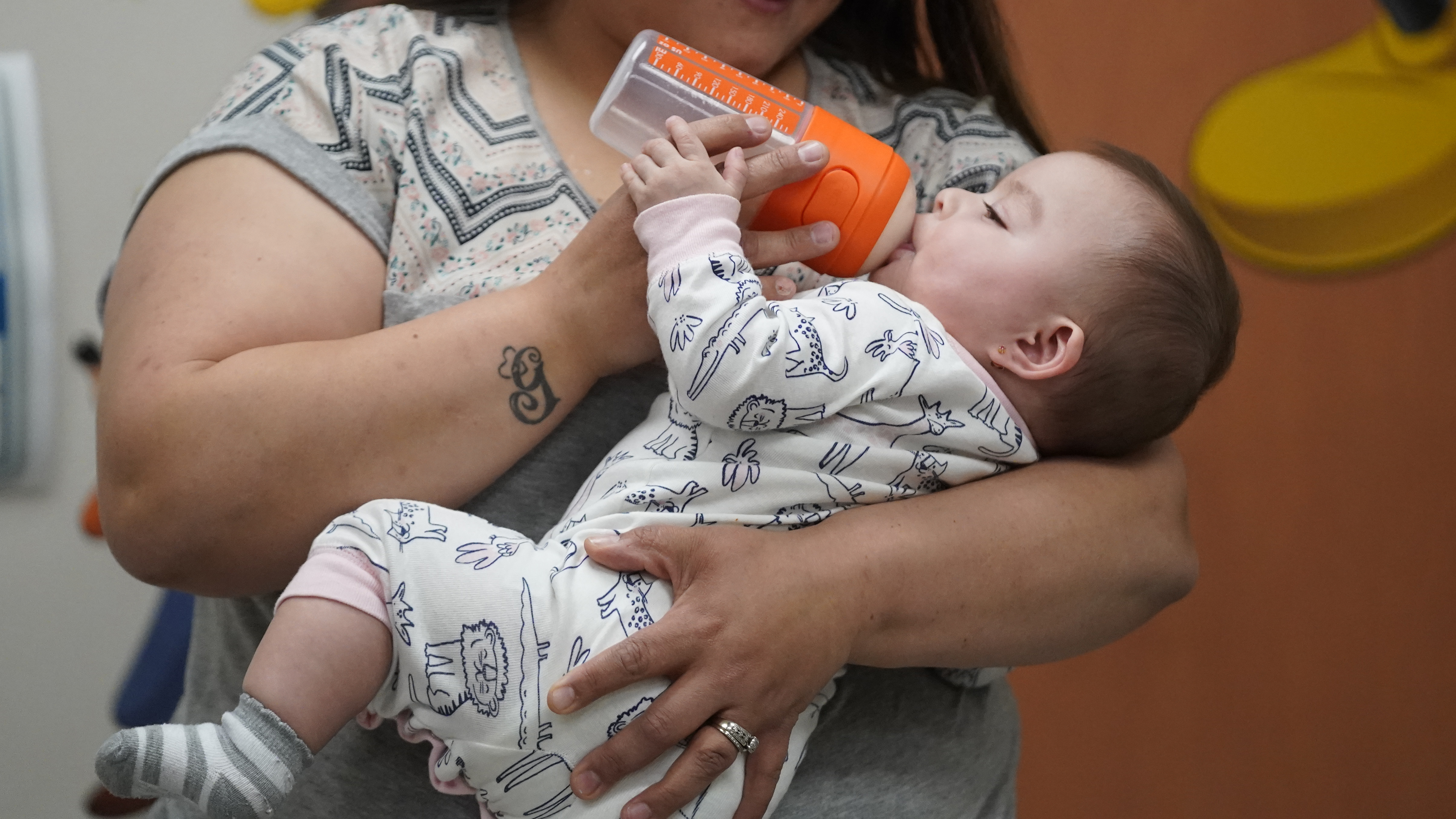 Elizabeth Amador bottle feeds her daughter Destinee, 9 months, at the Ellis R. Shipp Public Health Center Thursday, May 12 in West Valley City, Utah. President Joe Biden stepped up his administration's response to a nationwide baby formula shortage Thursday, May 12, that has forced frenzied parents into online groups to swap and sell to each other to keep their babies fed.