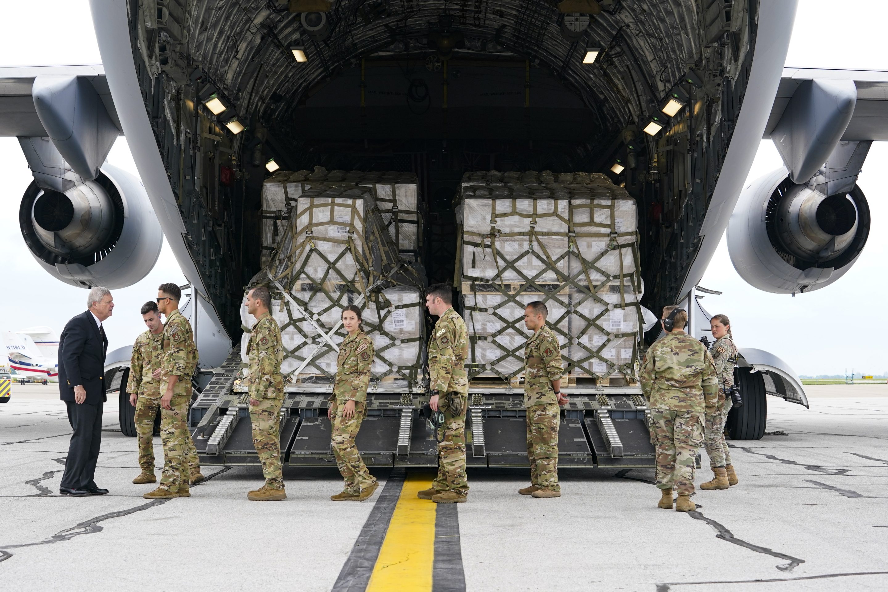 Agriculture Secretary Tom Vilsack, left, greets crew members of a C-17 that delivered a plane load of baby formula at the Indianapolis International Airport in Indianapolis, Sunday, May 22. The 132 pallets of Nestlé Health Science Alfamino Infant and Alfamino Junior formula arrived from Ramstein Air Base in Germany.