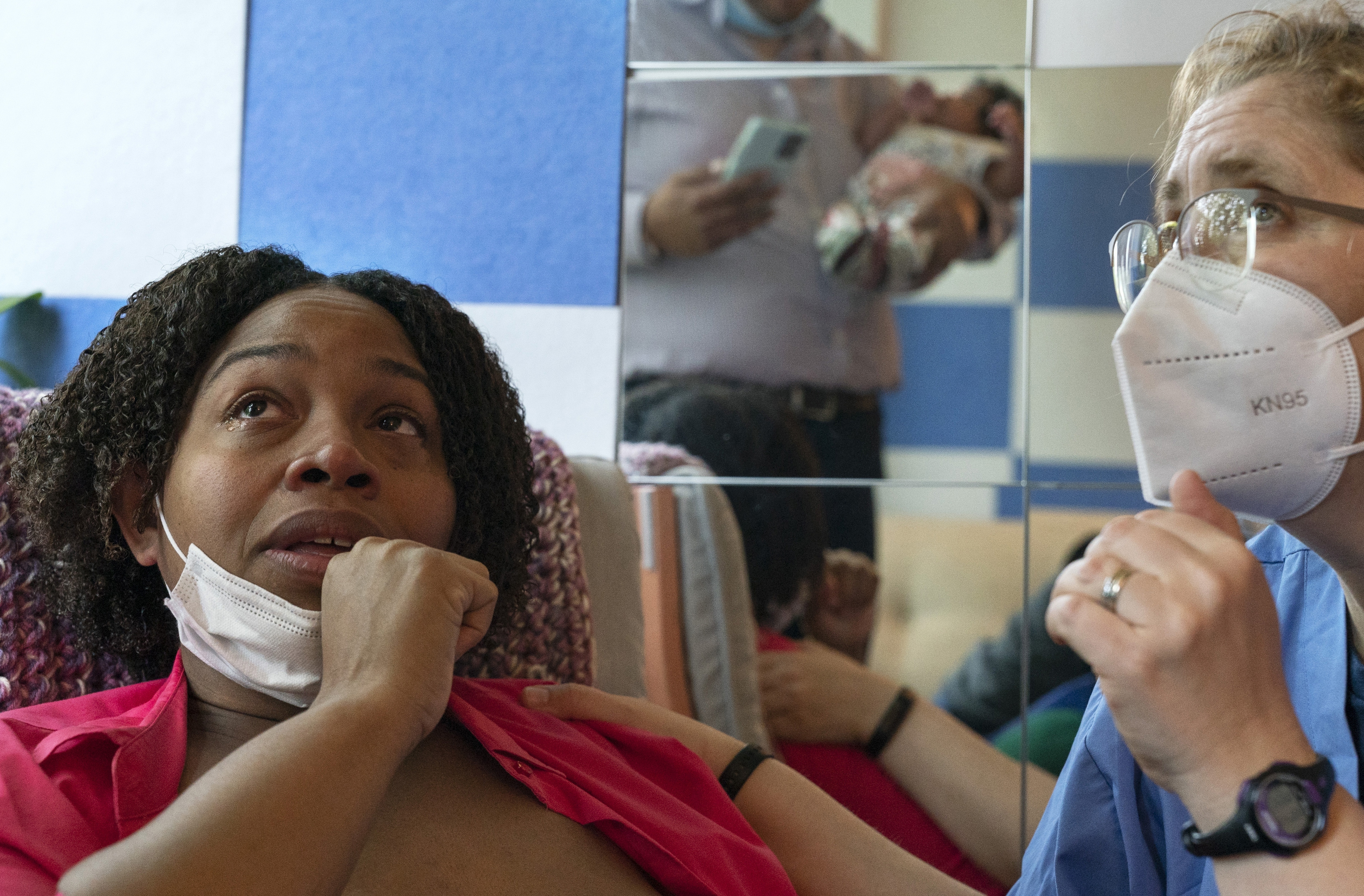 Capri Isidoro, of Ellicott City, Md., left, looks up at her husband and baby as she is overwhelmed with emotion as Ann Faust, an International Board Certified Lactation Consultant (IBCLC), tells her that she feels Isidoro can exclusively breastfeed if she so desires, Monday, May 23, as part of a lactation consultation in Columbia, Md., at Baby and Me Lactation Services. Baby Charlotte was delivered via emergency c-section and given formula at the hospital. Isidoro has been having trouble with breastfeeding and has been searching for a formula that her daughter can tolerate well. "If all things were equal I would feed her with formula and breastmilk," says Isidoro, "but the formula shortage is so scary. I worry I won't be able to feed my child."