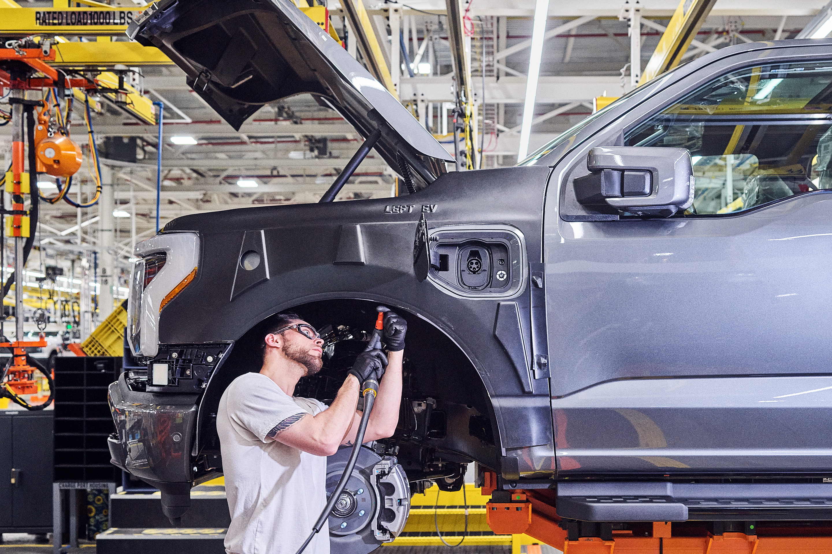 A NEW MODEL T?: A Ford employee works on an F-150 Lightning, the model Ford hopes will woo more U.S. drivers to EVs.