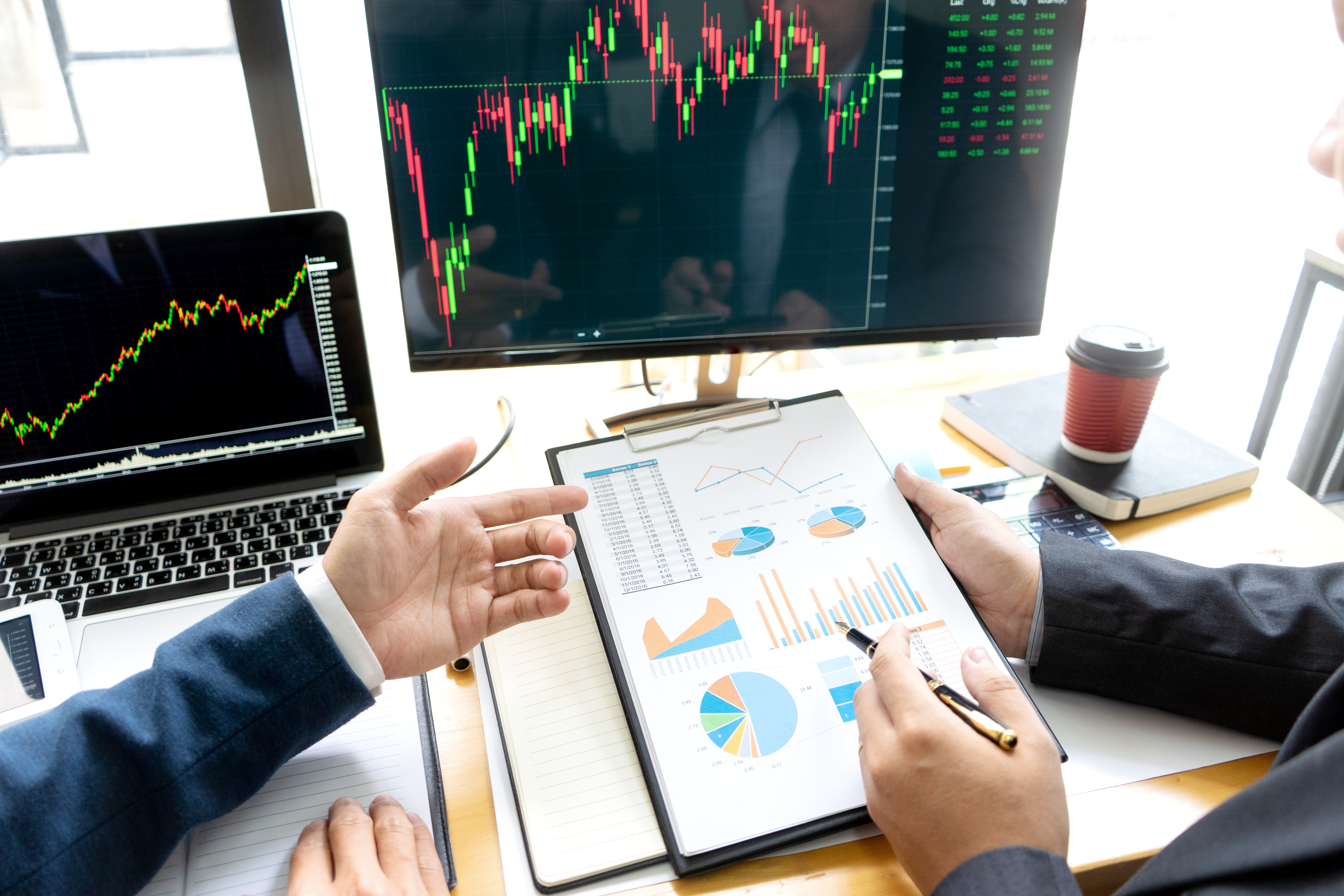 businessman sit at ther table looking at computer laptop in the office , they talking about stock market invest or talk with customer