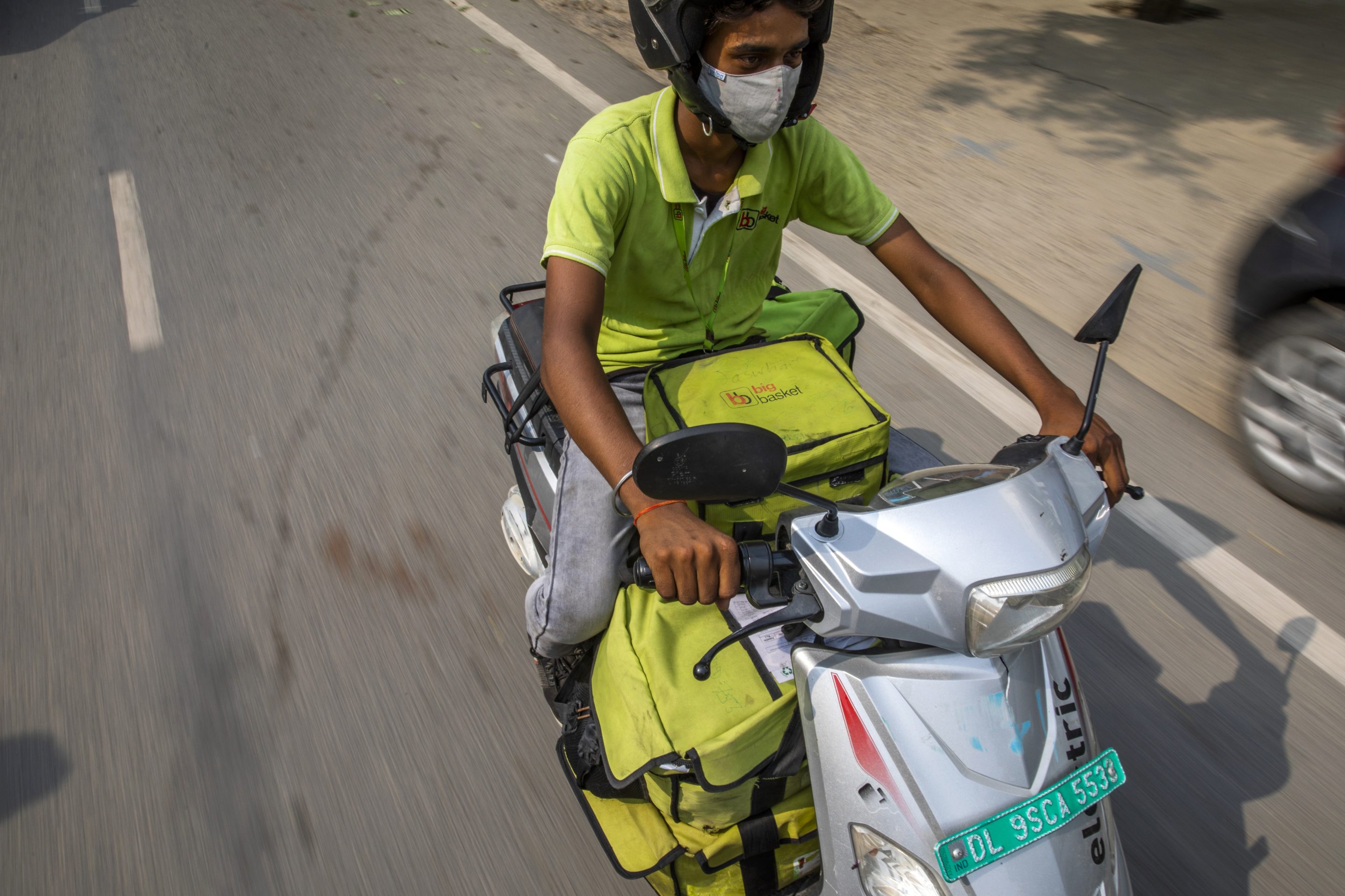 A food delivery rider fulfills orders with an electric scooter in Noida, Uttar Pradesh, India, on June 28, 2021.
