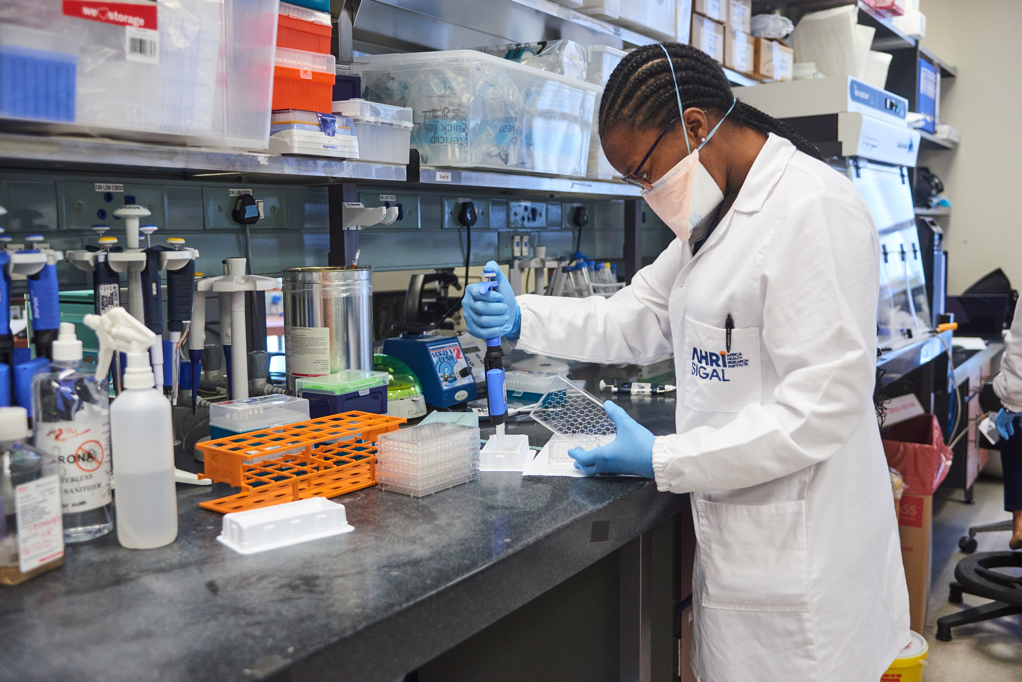 A technician uses a multi-channel pipette dropper to dispense material during Covid-19 antibody neutralization testing in a laboratory at the African Health Research Institute (AHRI) in Durban, South Africa, on Dec. 15, 2021.
