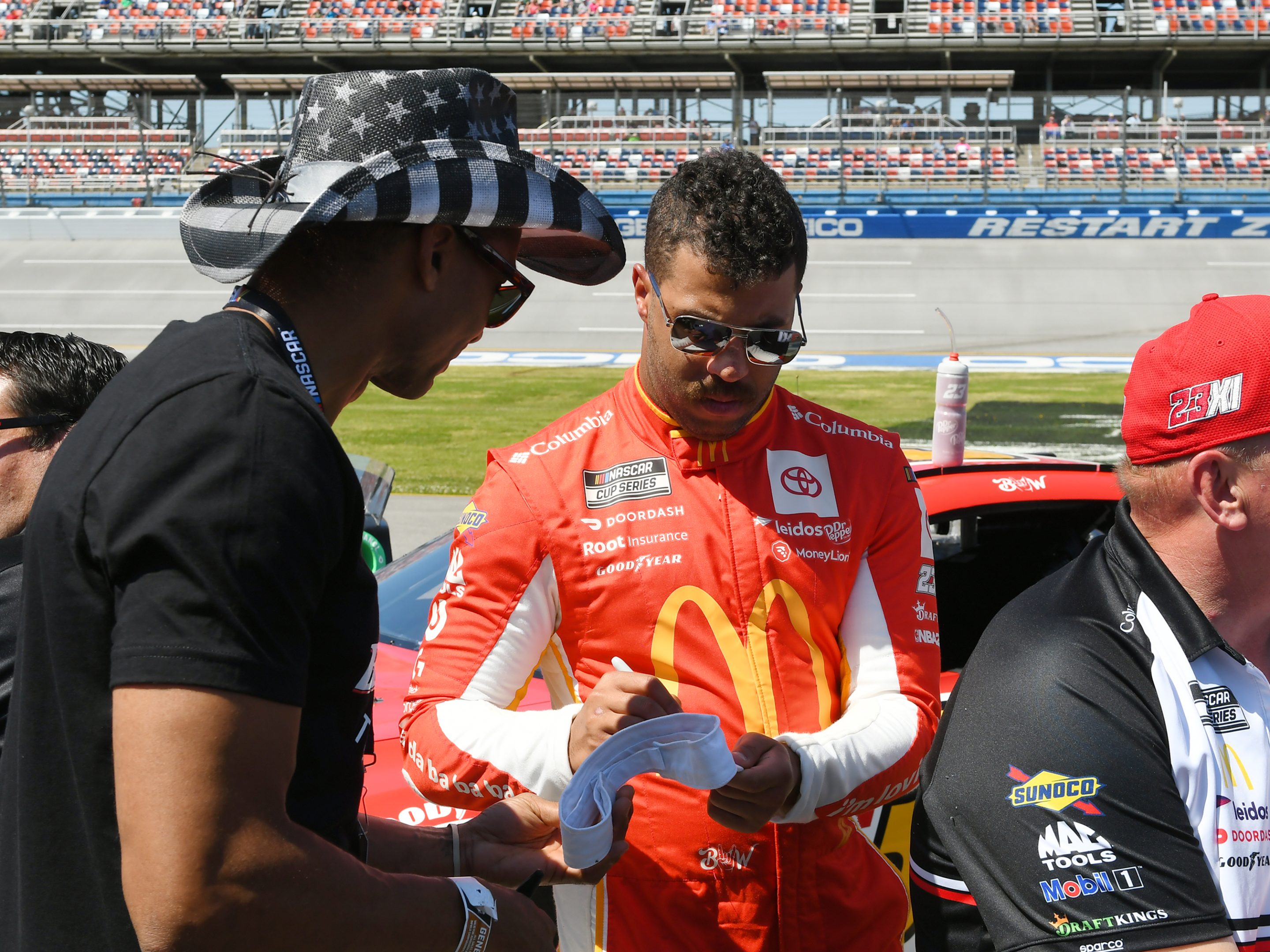 Bubba Wallace signs an autograph for a fan during the qualifying for the NASCAR Cup Series Geico 500 in April.