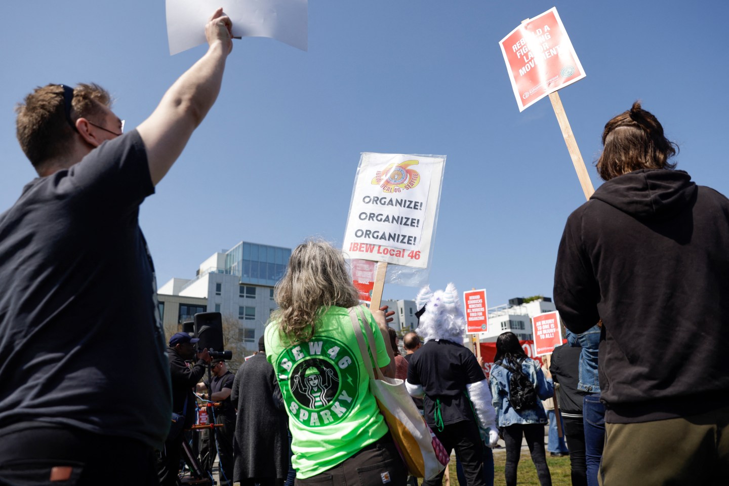 People hold signs during the "Fight Starbucks' Union Busting" rally and march in Seattle.