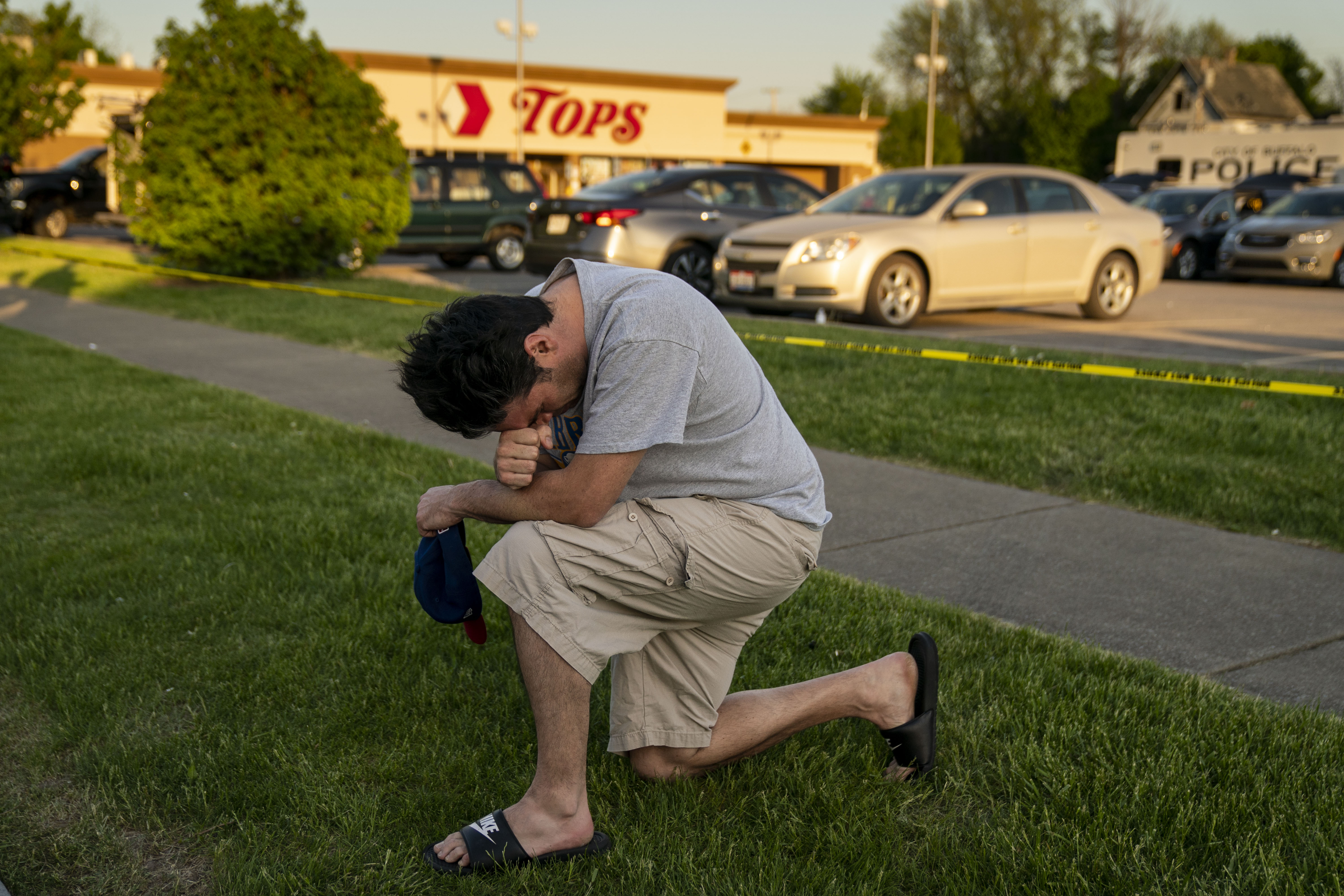 Jesse Gordon of Buffalo, pays his respects as people gather at the scene of a mass shooting at Tops Friendly Market.