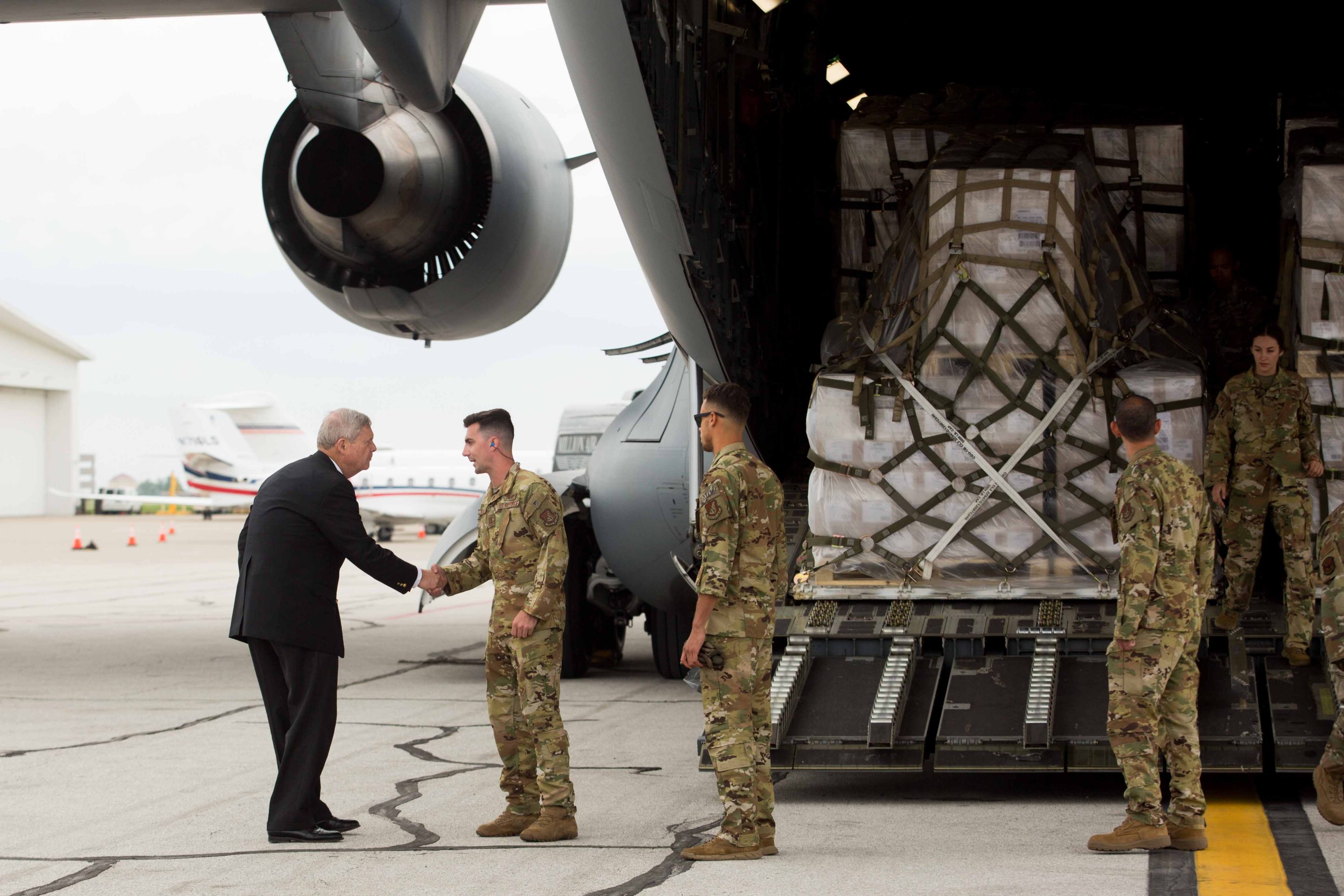 Tom Vilsack, US agriculture secretary, left, greets members of the United States Transportation Command at Indianapolis International Airport on Sunday, May 22, 2022. 