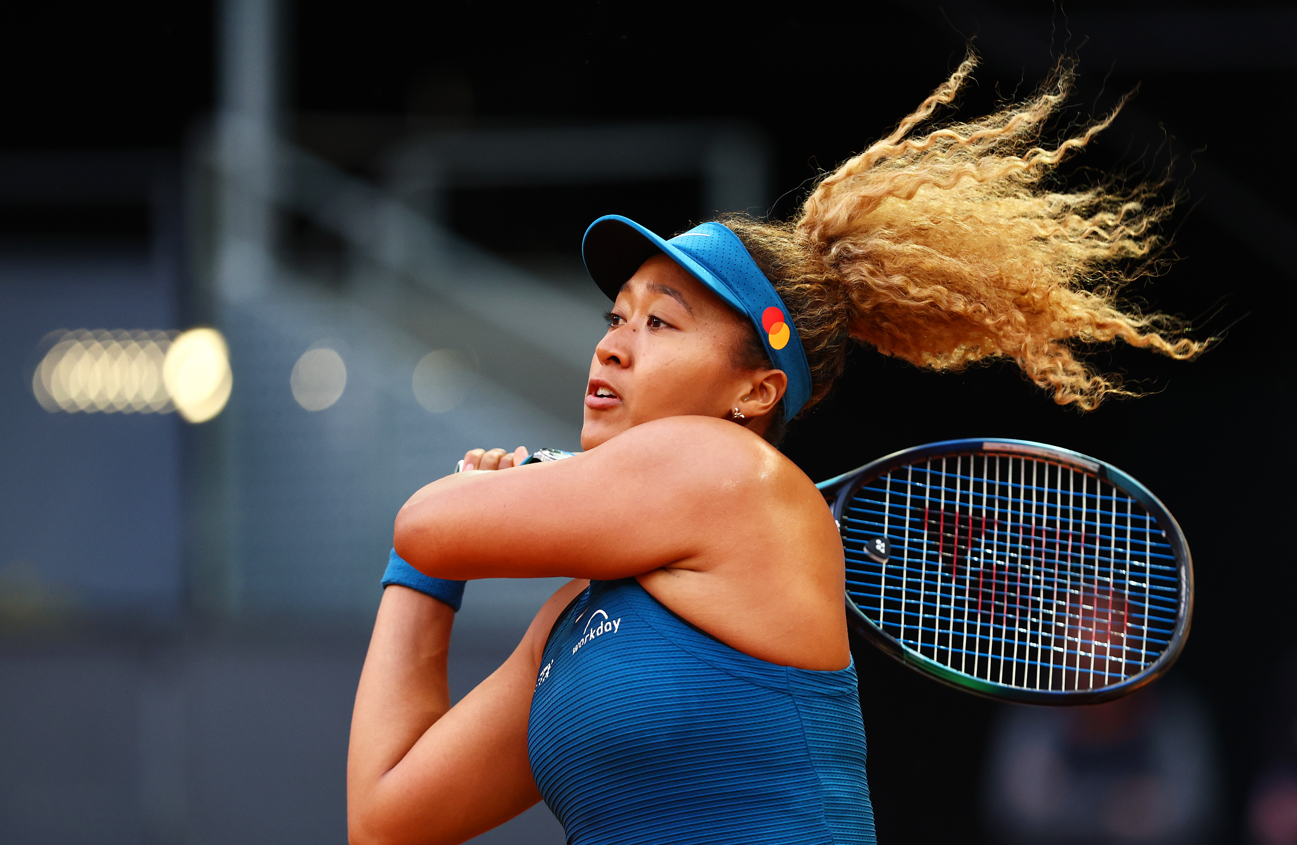 Naomi Osaka plays a backhand against against Sara Sorribes Tormo of Spain during their Round of 32 match on Day Four of the Mutua Madrid Open at La Caja Magica on May 1, 2022 in Madrid, Spain.