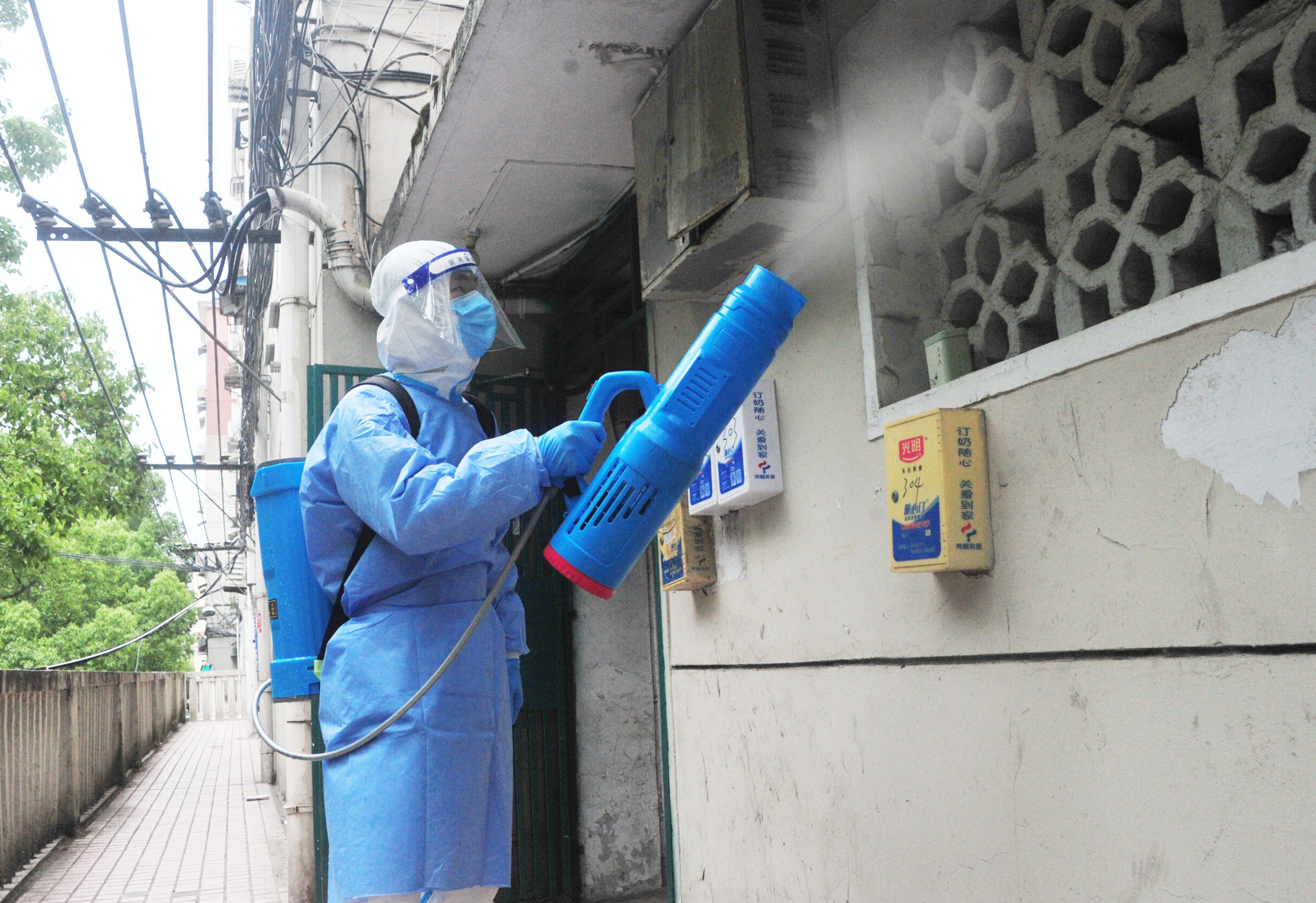 A health worker sprays disinfectant at a gated community in locked-down Shanghai on May 11, 2022. The head of the WHO recently said that China’s zero-COVID policy, which has led to Shanghai’s strict six-week lockdown, is unsustainable.