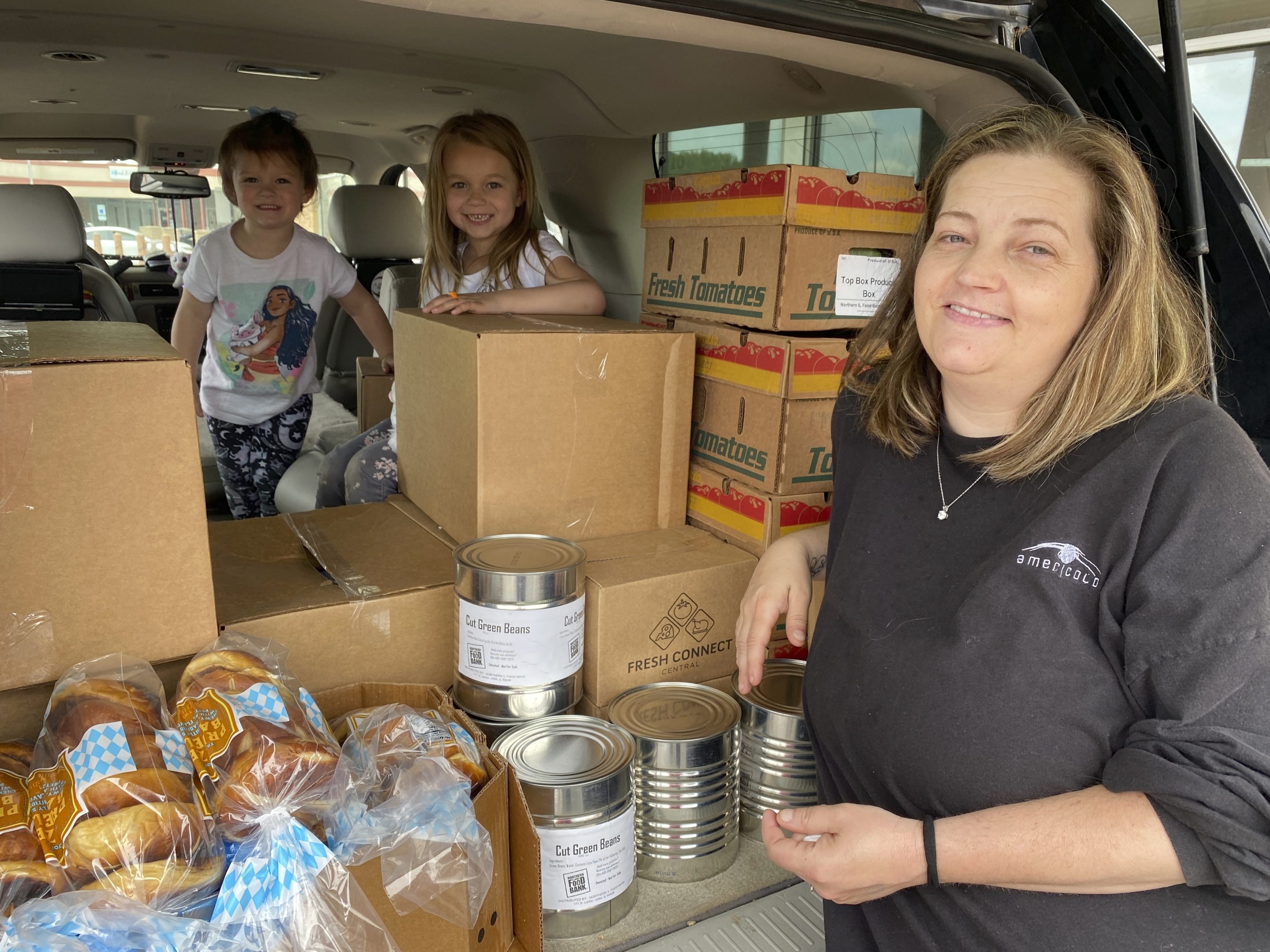 In this image provided by the Northern Illinois Food Bank, Kisha Galvan and her grandchildren, pose for a photo after stocking up on food items from the Northern Illinois Food Bank on May 26 in Rockford, Ill. Galvan was able to stock up on groceries for the week and buy extras like clothing and shoes at Walmart for her children last year.