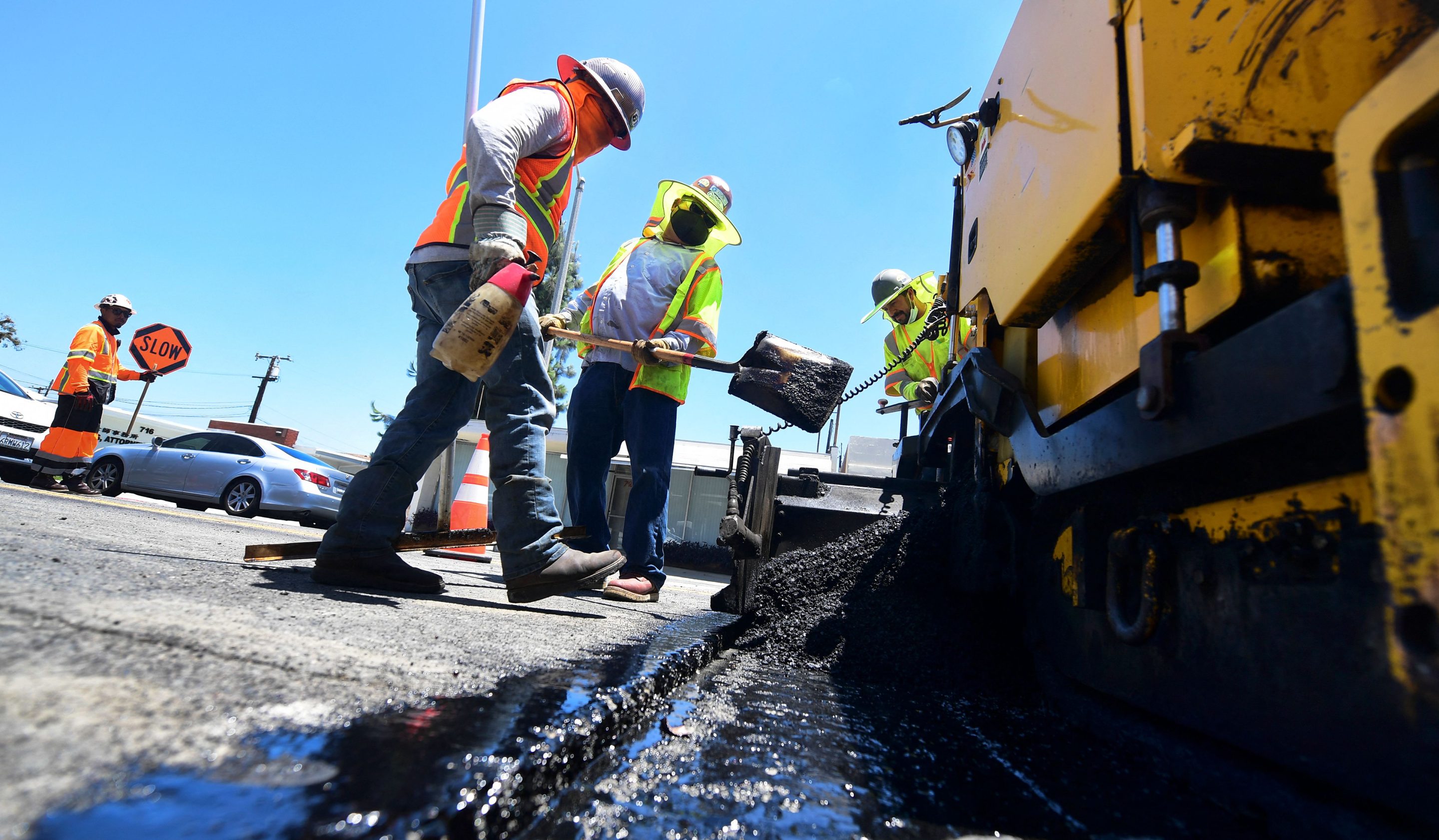A roadworks crew work on road resurfacing on June 24, 2021 in Alhambra, Calif. 