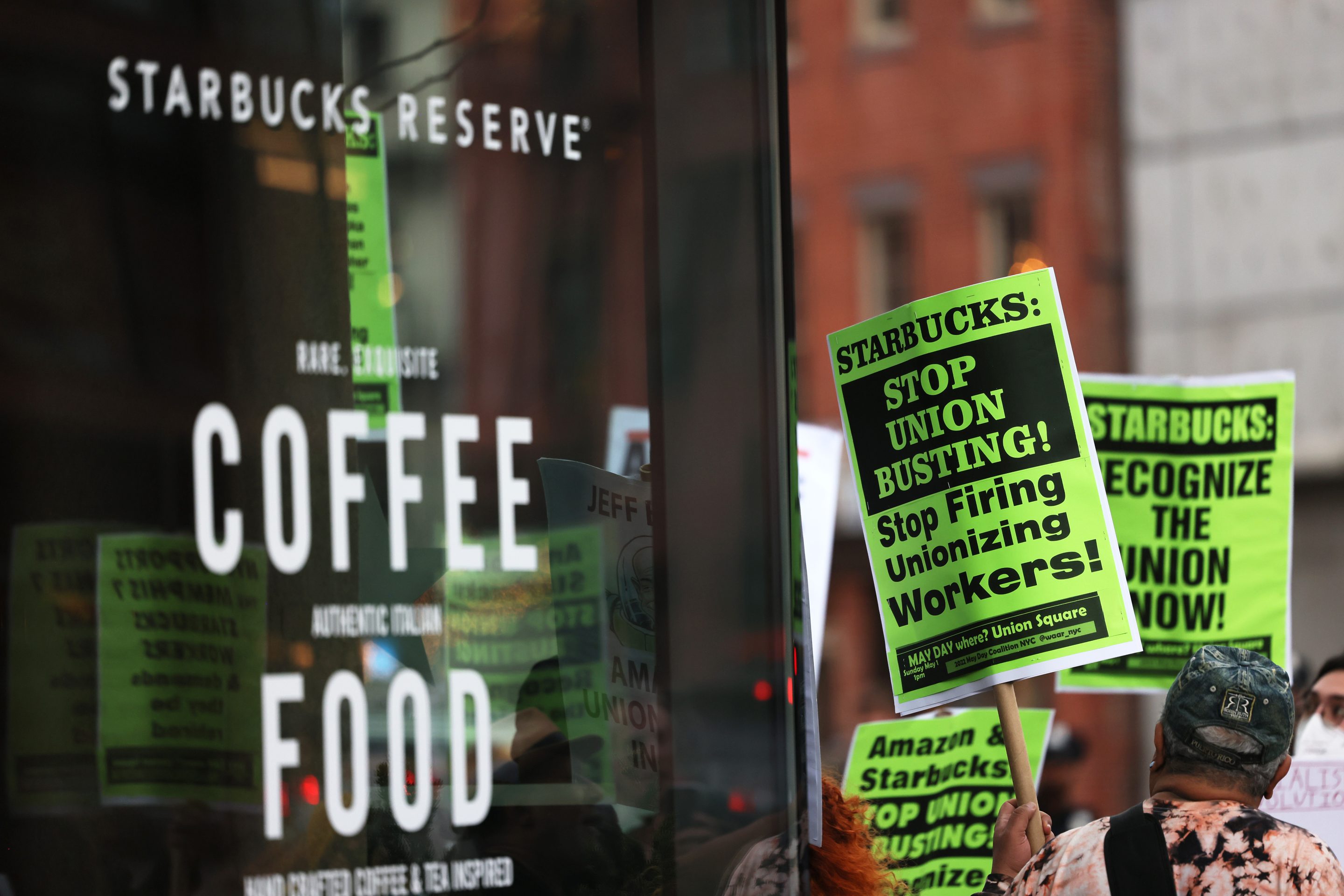 People hold signs while protesting in front of Starbucks on April 14in New York City. Activists gathered to protest Starbucks' CEO Howard Schultz anti-unionization efforts and demand the reinstatement of workers fired for trying to unionize.