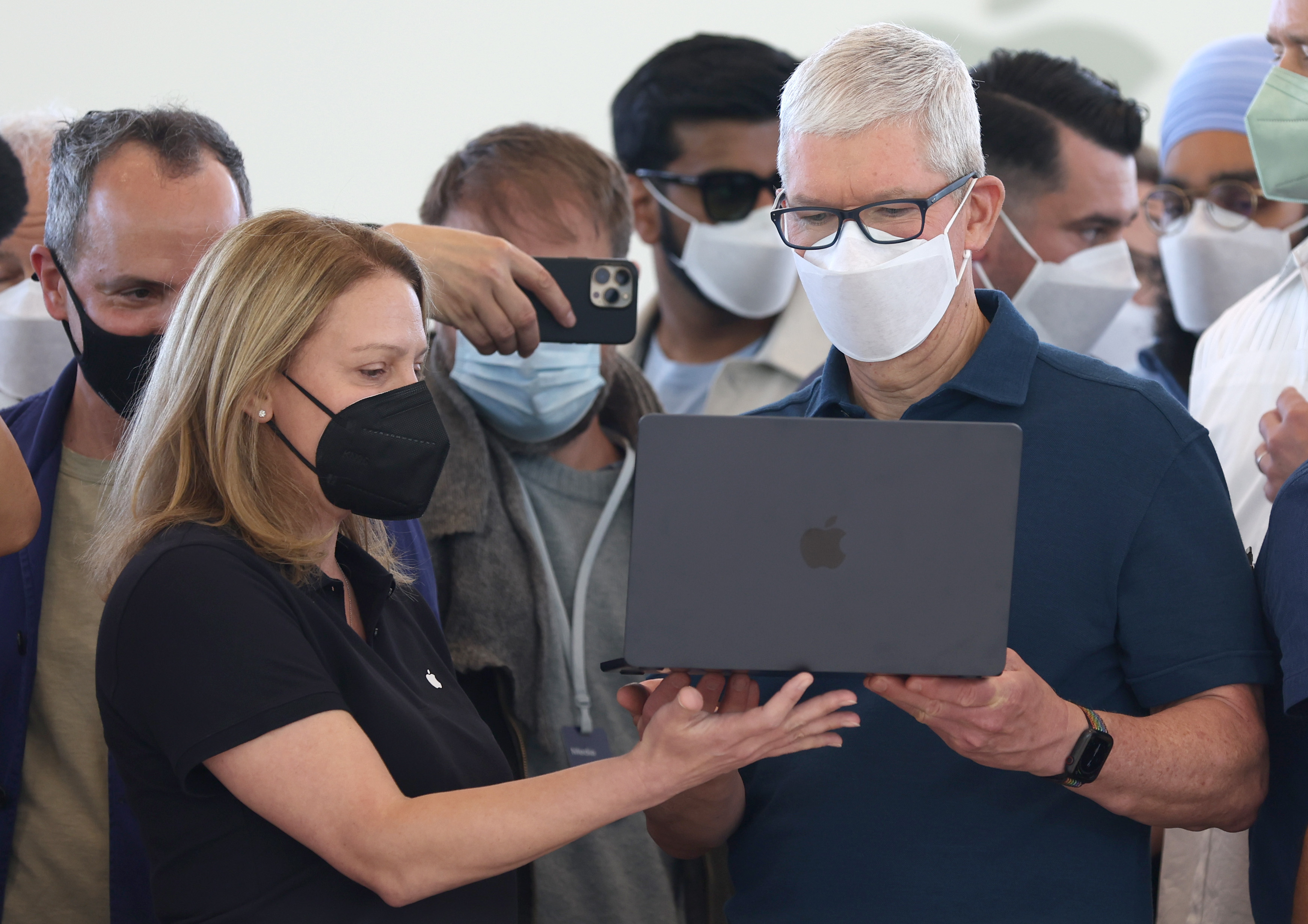Apple CEO Tim Cook looks at a newly redesigned MacBook Air laptop during the WWDC22 at Apple Park on June 6, 2022 in Cupertino, Calif.