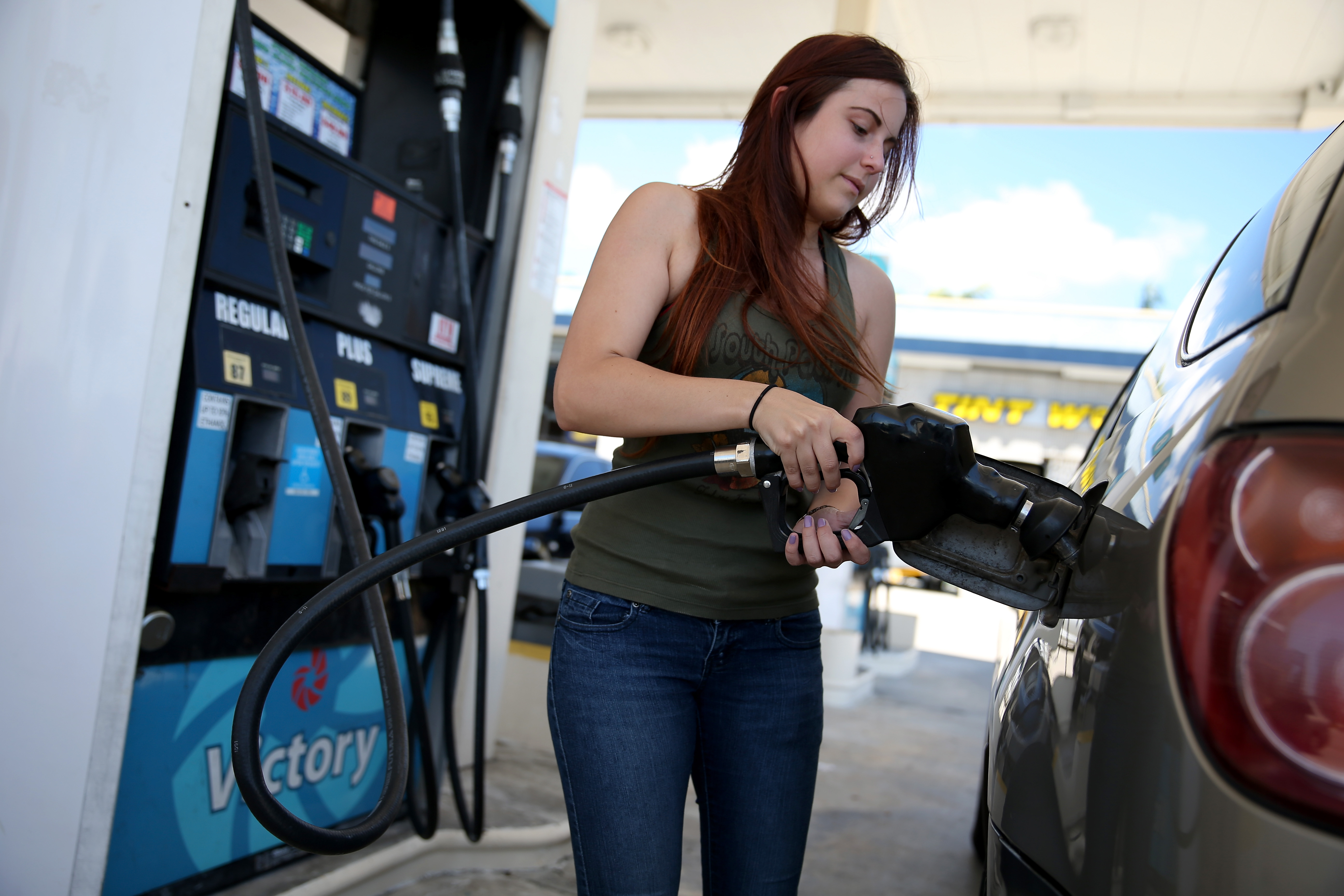 A woman filling up her gas tank