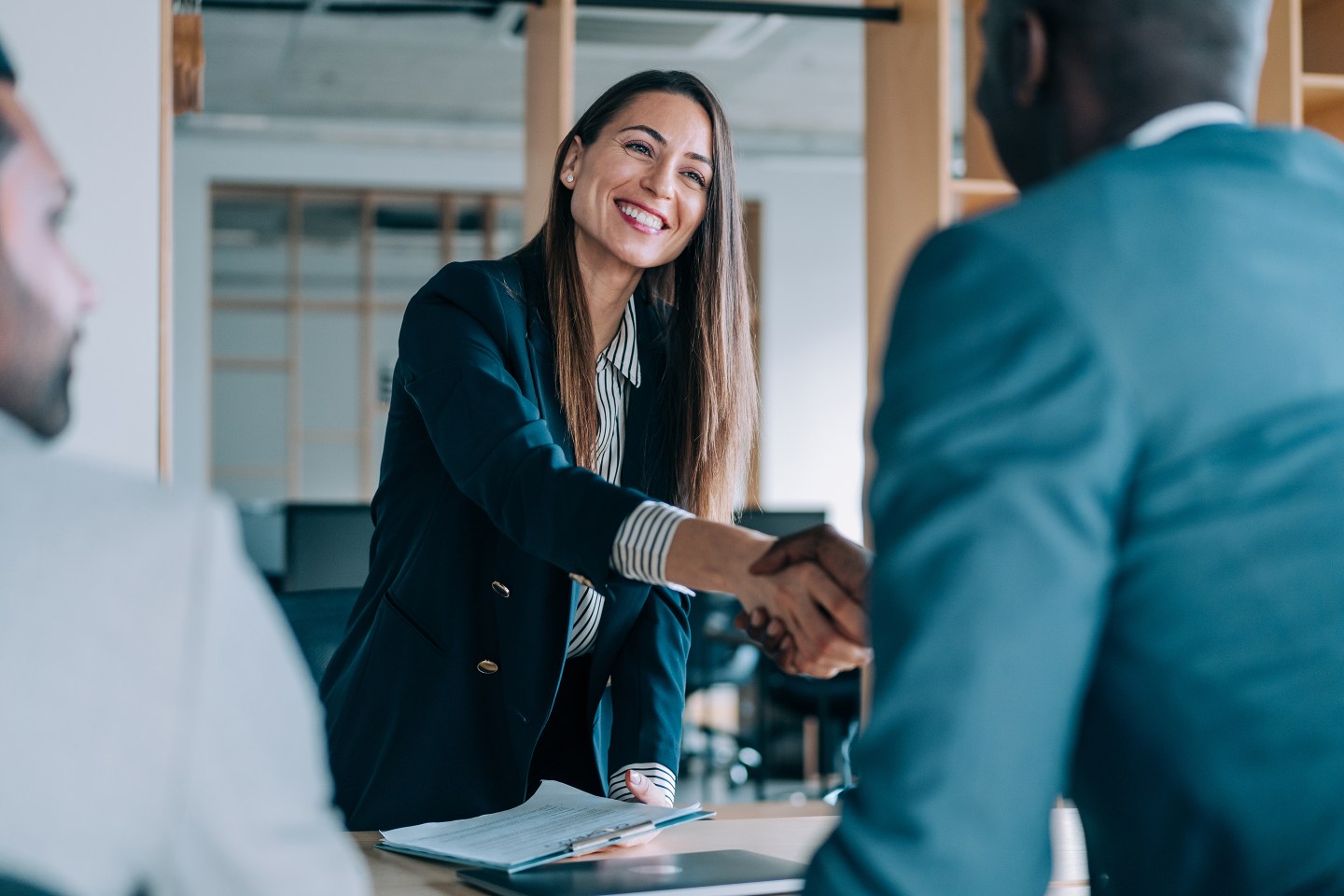 Woman shaking hand in business meeting.