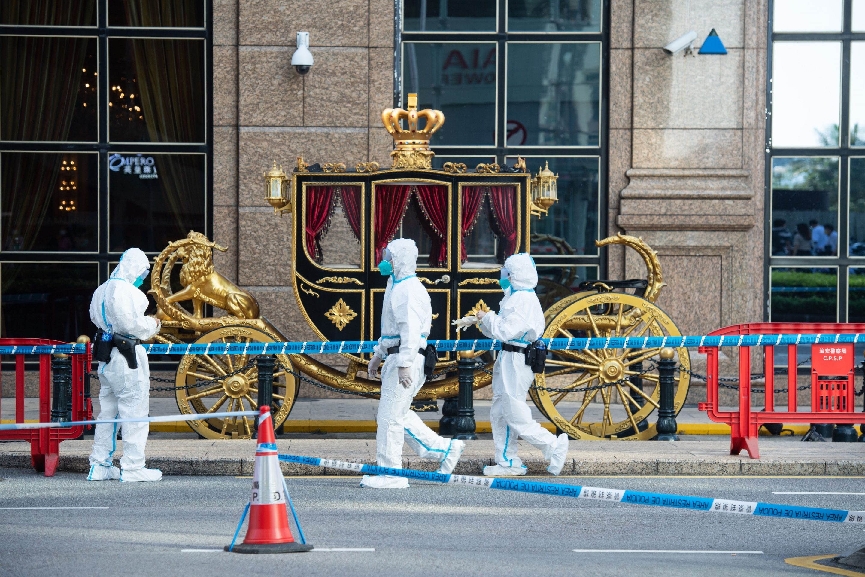 Police officers stand near a carriage outside a casino in Macau on Oct. 4, 2021. The region is experiencing its biggest-ever COVID outbreak. 