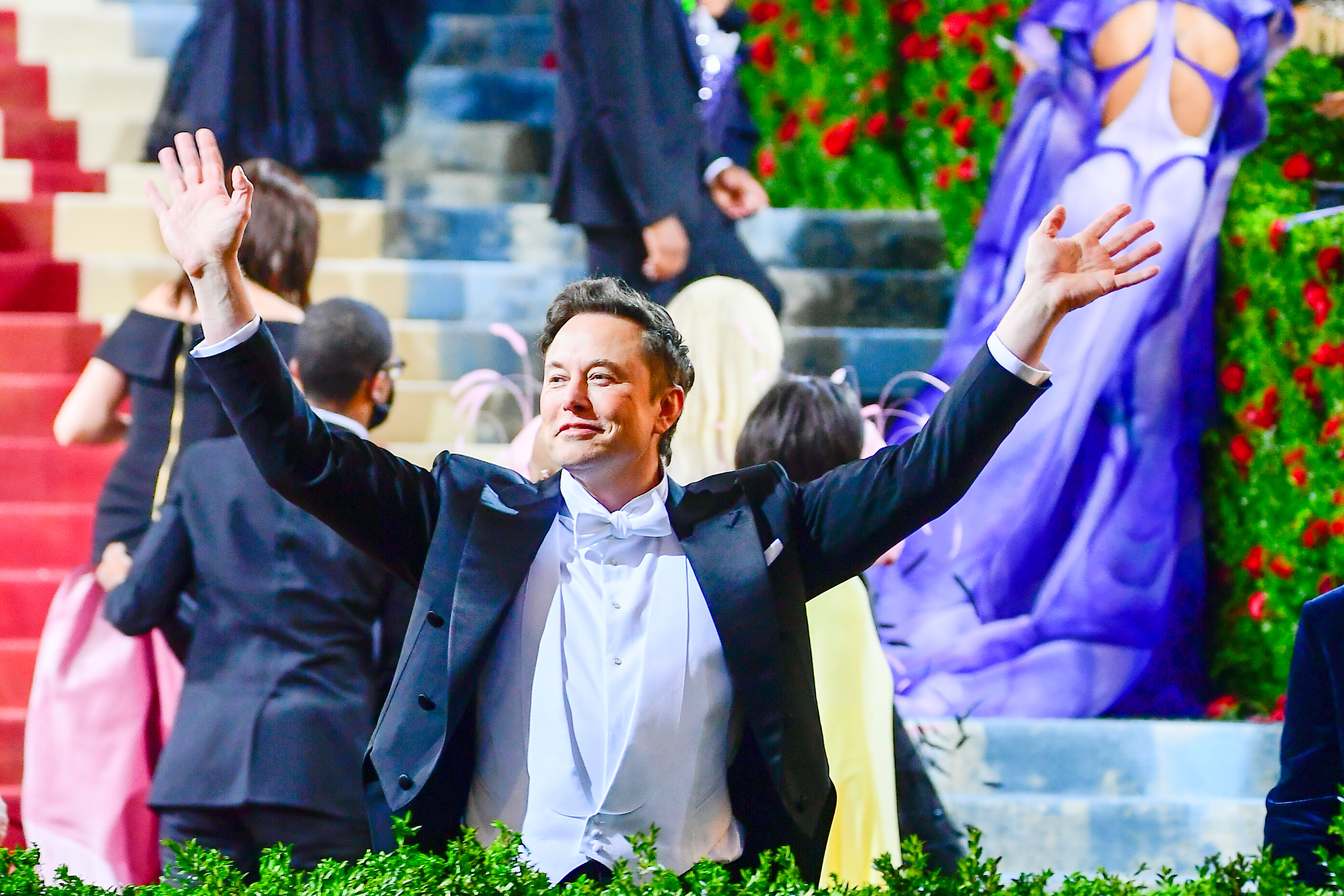 Elon Musk raises his hands