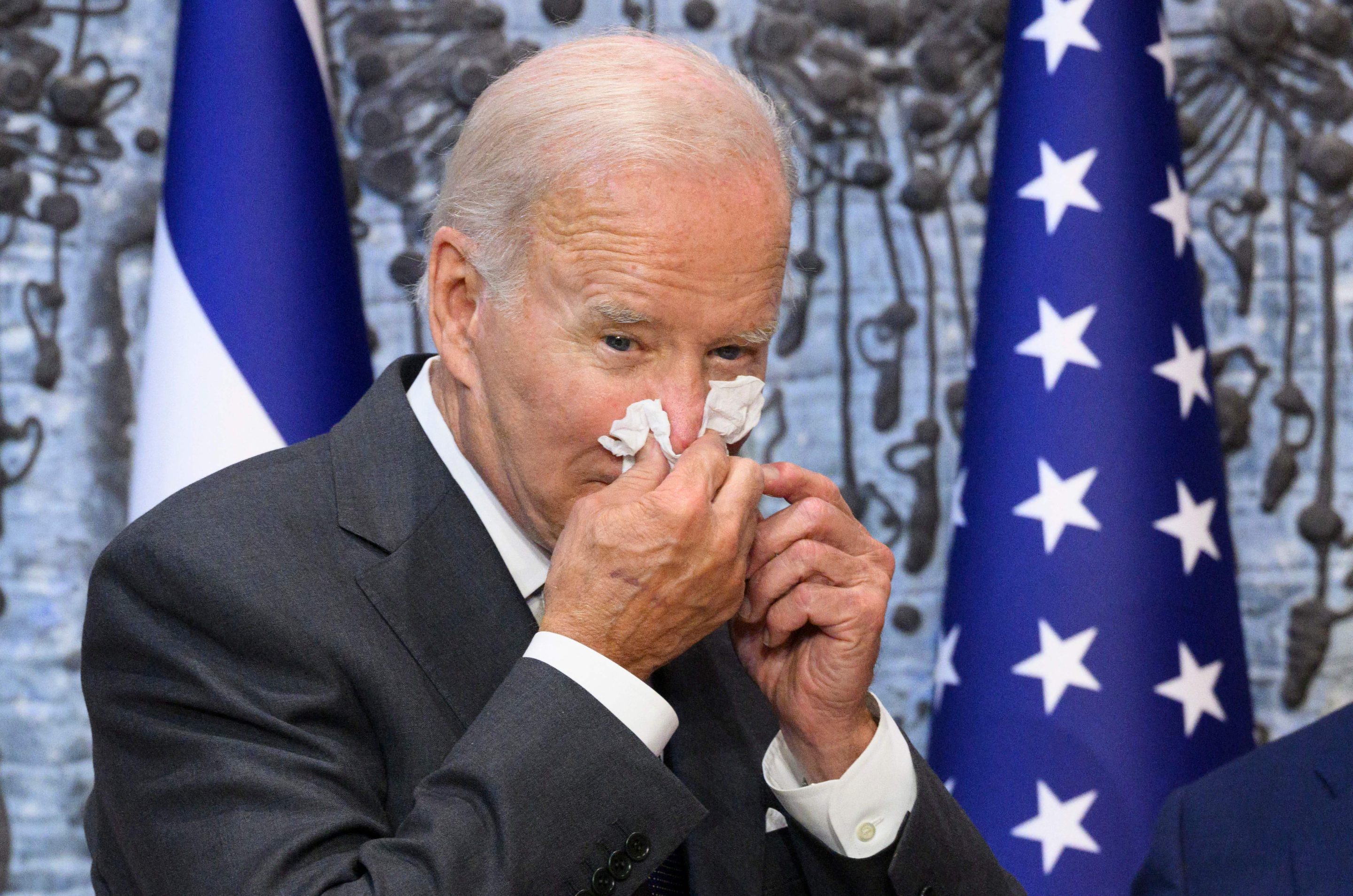 A July 14 photo shows U.S. President Joe Biden wiping his nose after signing the guest book while visiting Israel's President Isaac Herzog at Beit HaNassi, the presidential residence, in Jerusalem.
