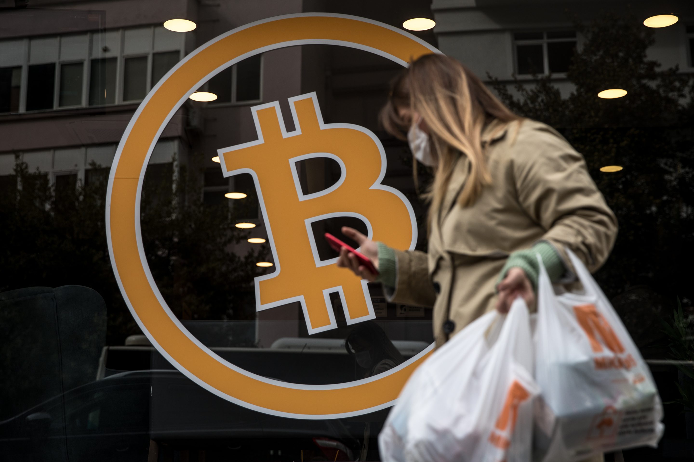 Photo of person walking by crypto exchange office.